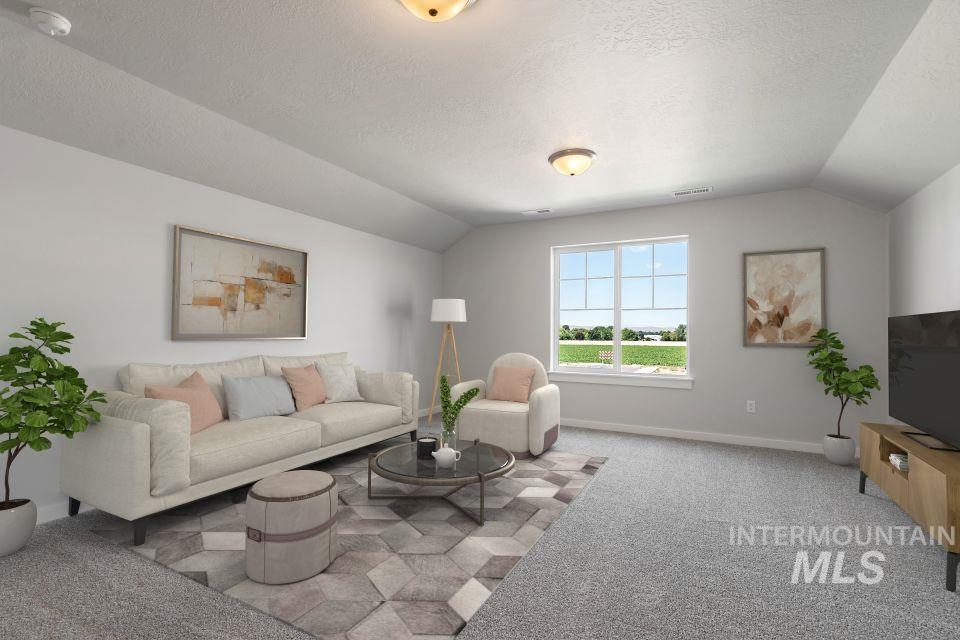 Living area featuring light carpet, lofted ceiling, and a textured ceiling
