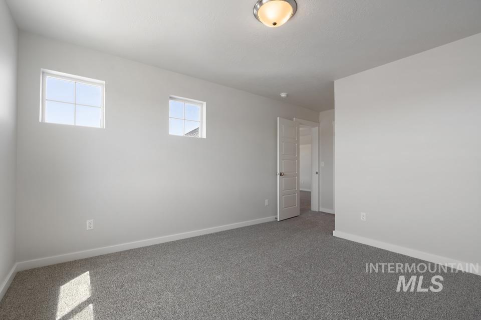 Carpeted spare room with baseboards