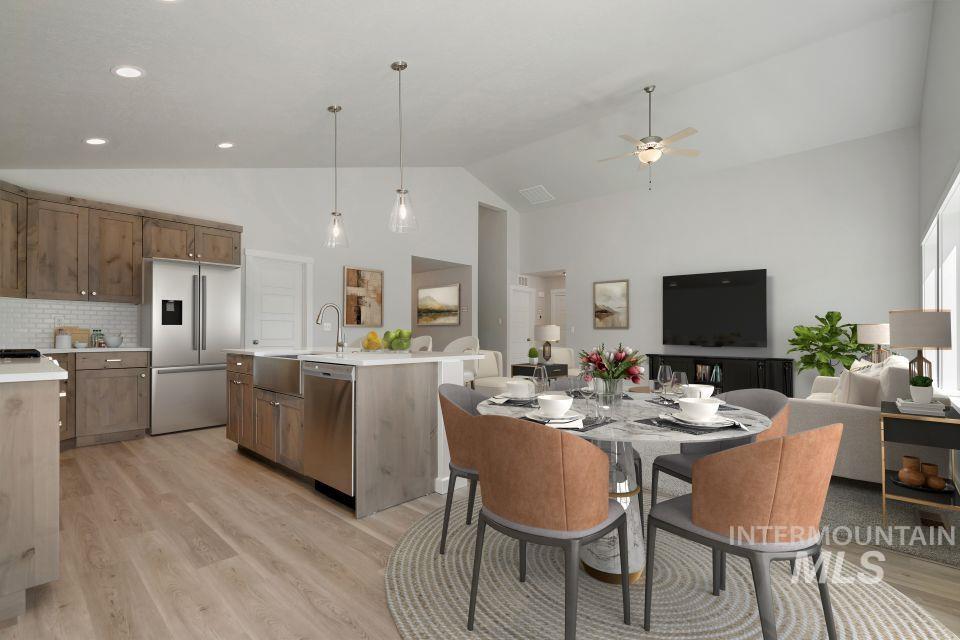 Dining space featuring light wood-type flooring, a ceiling fan, and high vaulted ceiling