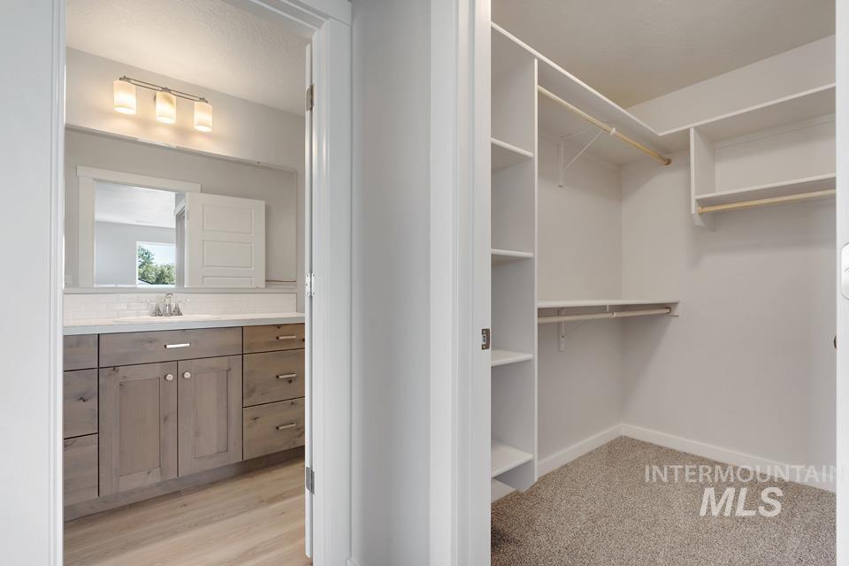 Spacious closet with a sink and light wood finished floors
