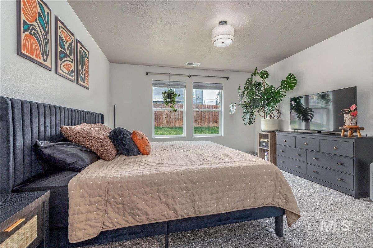 Bedroom with a textured ceiling and carpet