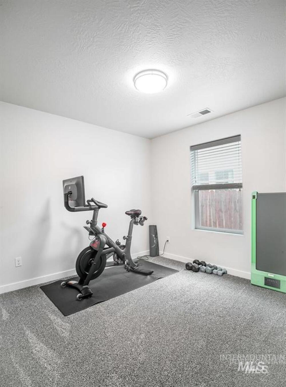Workout area featuring a textured ceiling and carpet