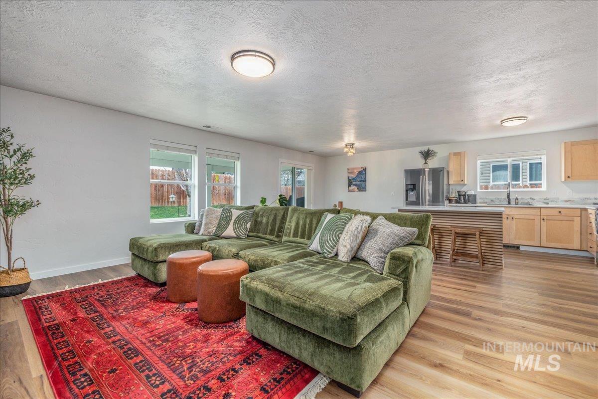 Living area featuring a textured ceiling and light wood-style flooring