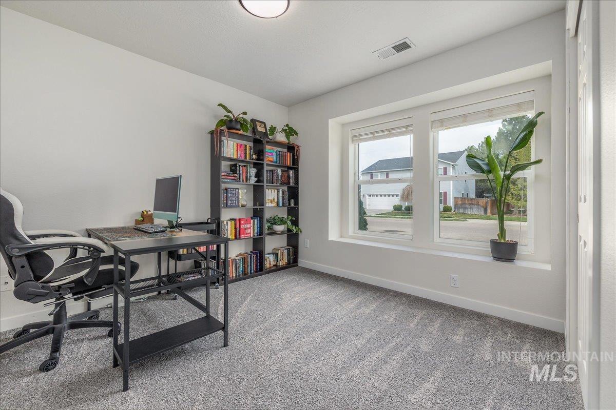 Office area featuring baseboards and light carpet
