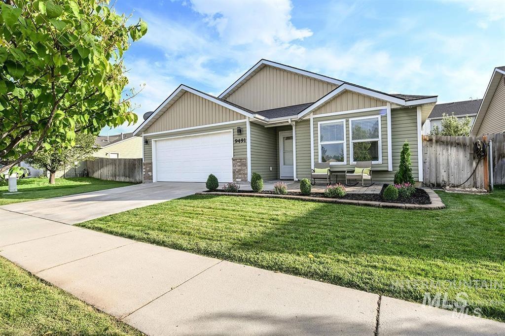 View of front facade featuring driveway, a garage, and board and batten siding
