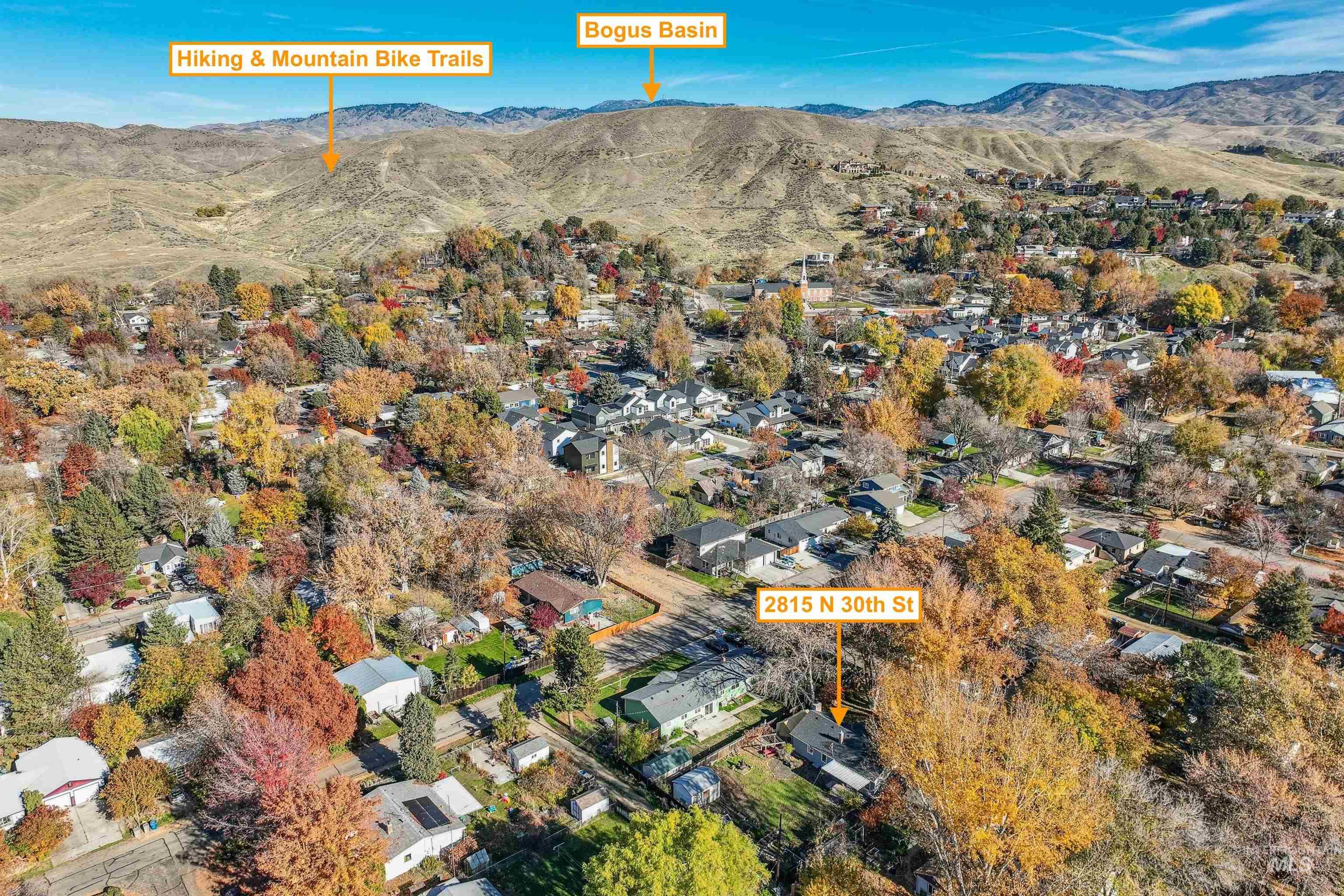 Aerial view of property's location featuring nearby suburban area and mountains