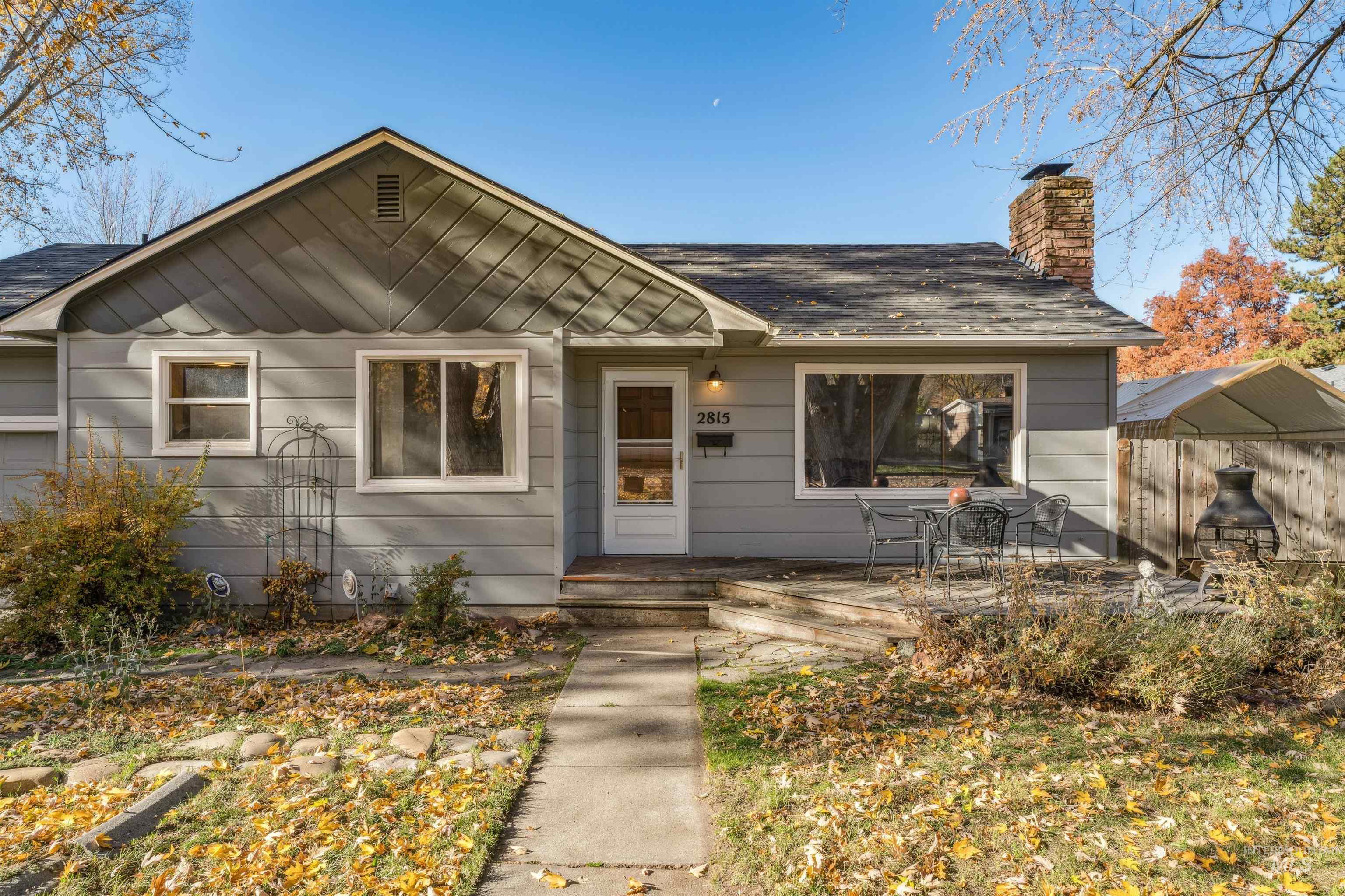 View of front of house with a chimney and a shingled roof