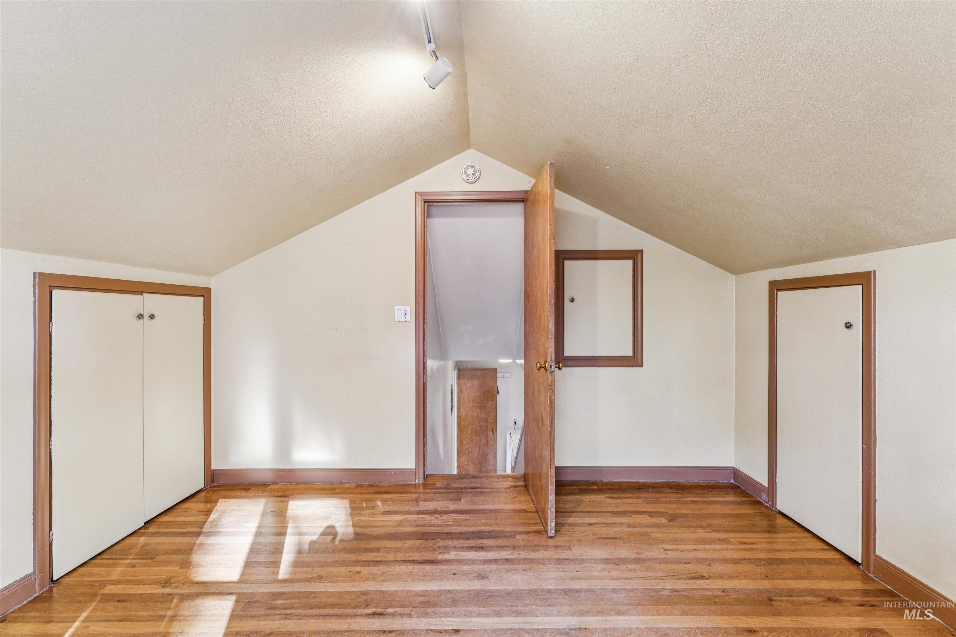 Bonus room featuring wood finished floors and vaulted ceiling
