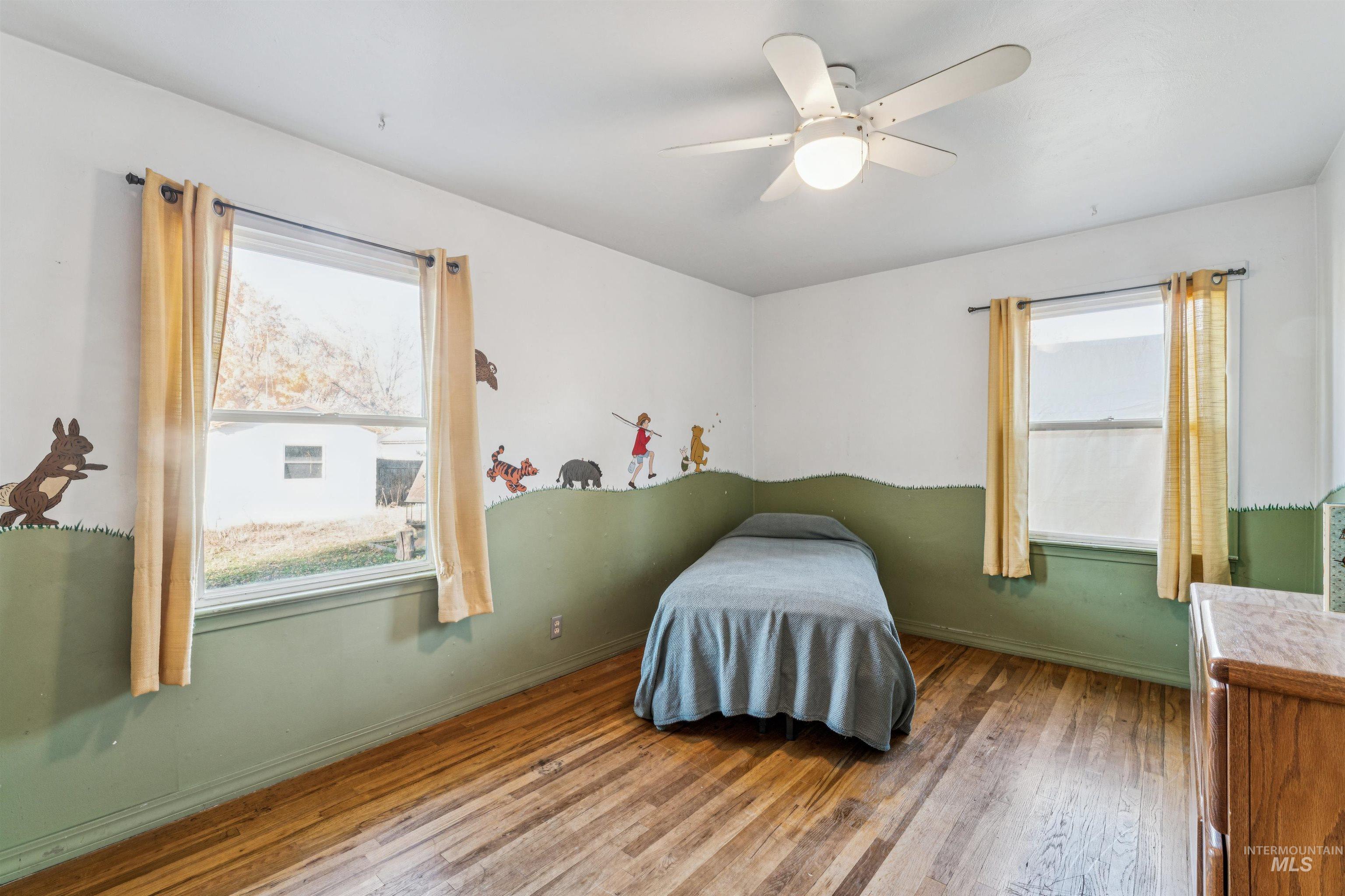 Bedroom with hardwood / wood-style floors and ceiling fan