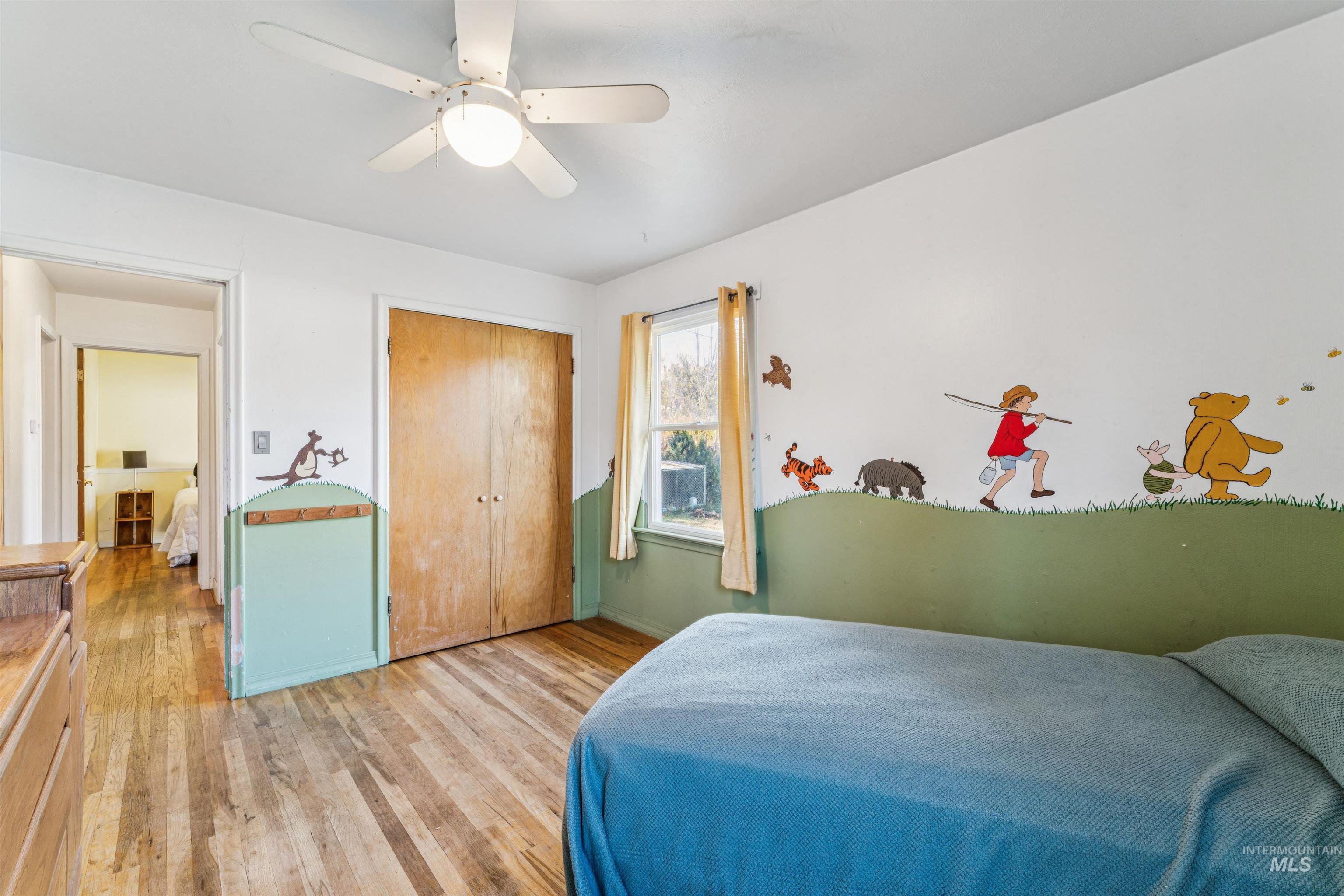Bedroom with wood finished floors, a ceiling fan, and a closet