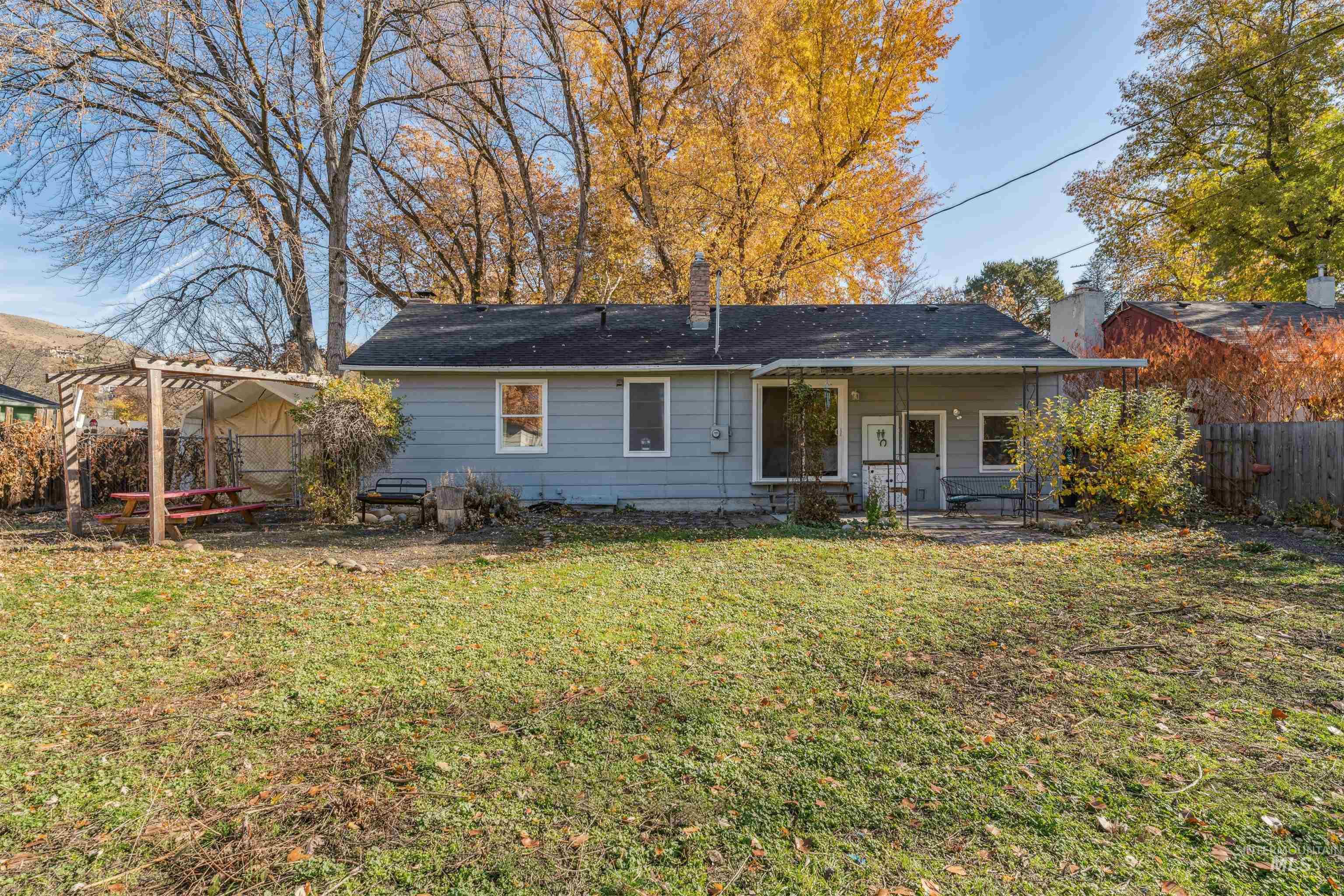 Rear view of property featuring a chimney and covered porch