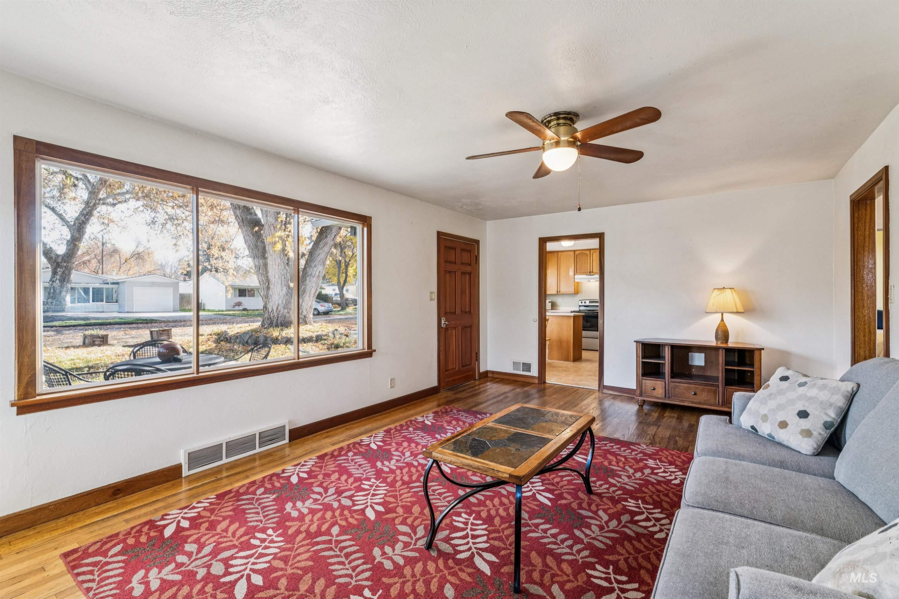 Living area with wood finished floors and ceiling fan