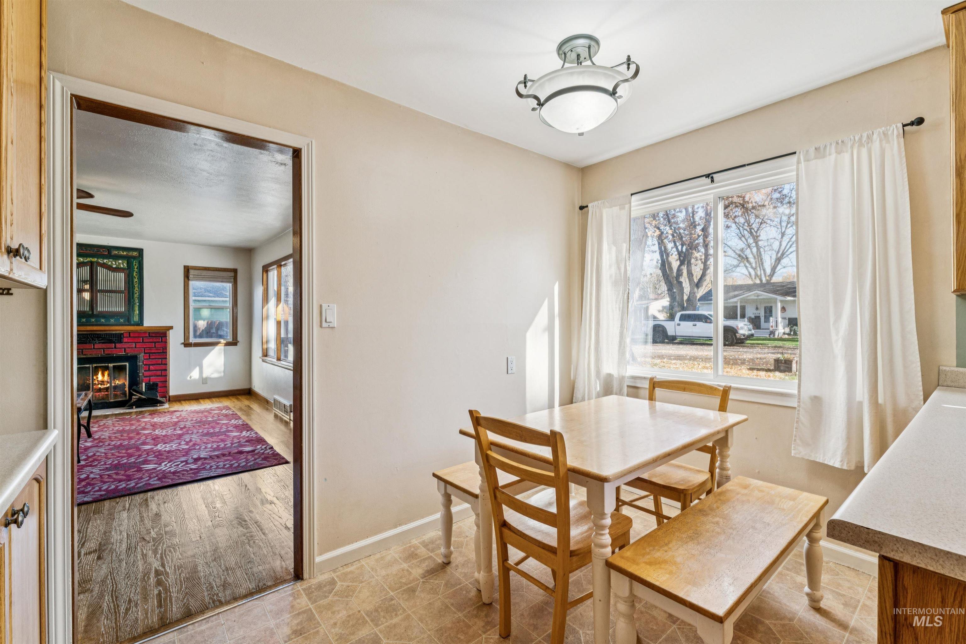 Dining area featuring a brick fireplace and light tile patterned floors