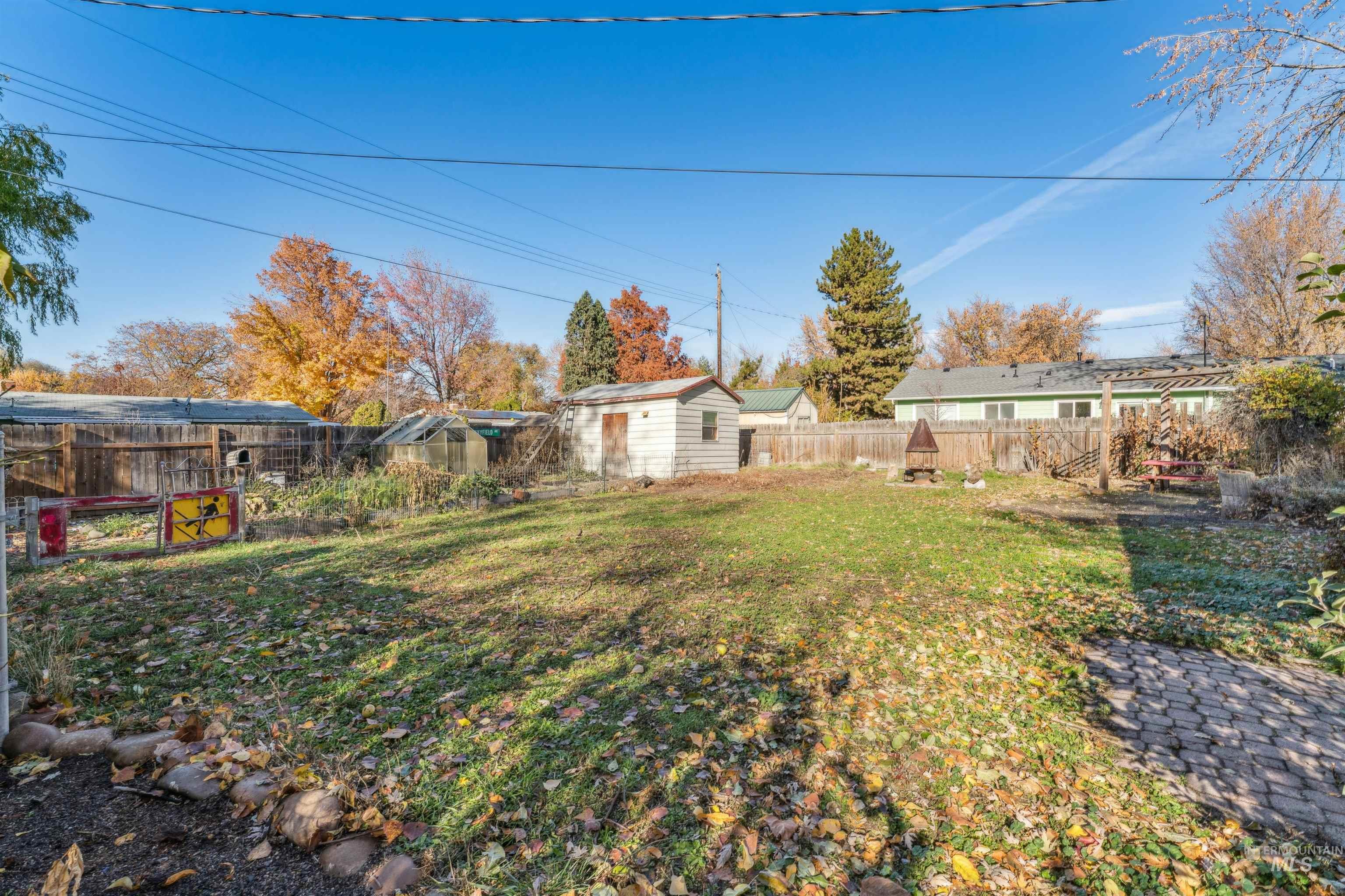 Fenced backyard featuring a storage shed