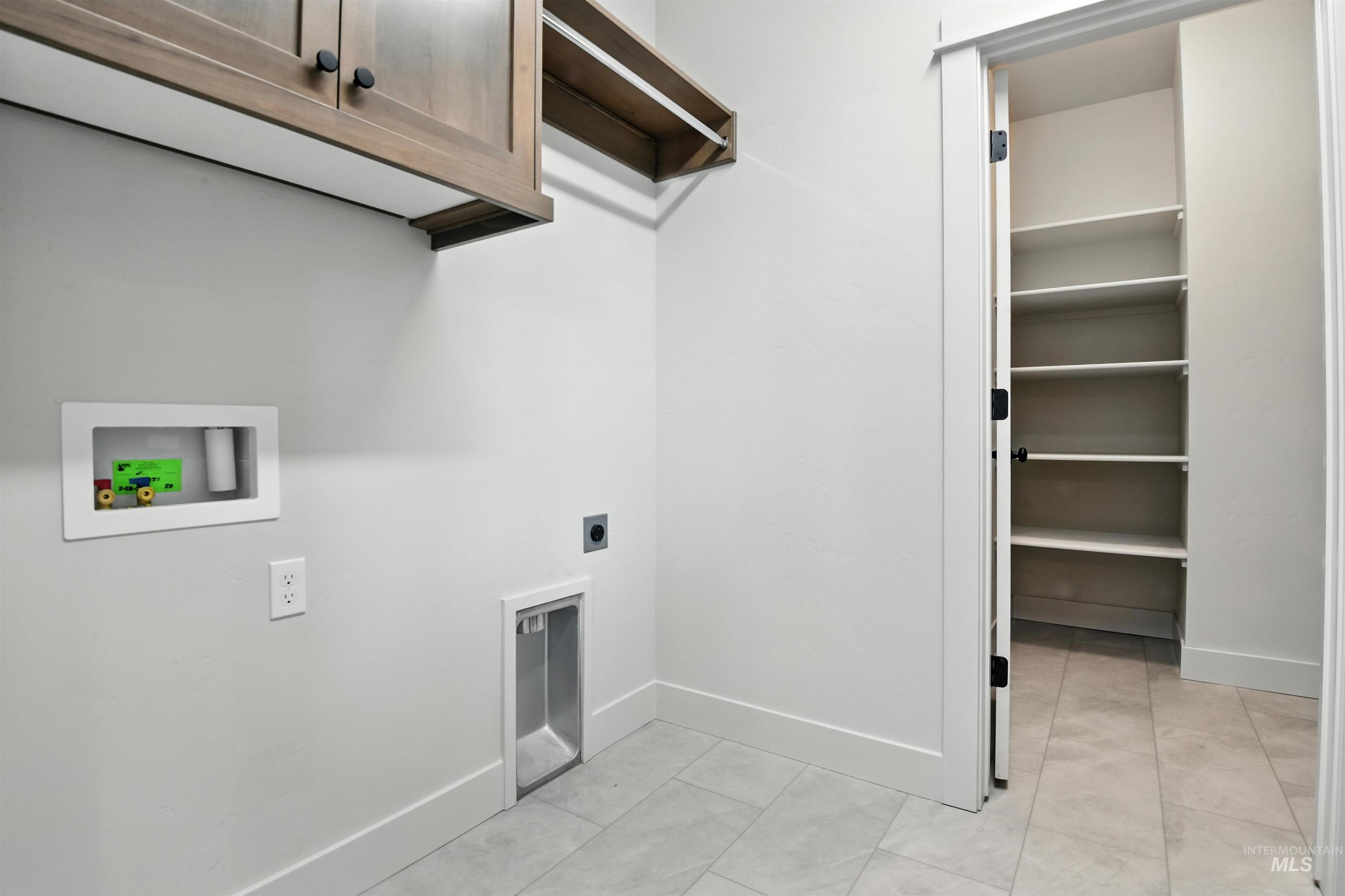 Washroom with cabinet space, hookup for an electric dryer, and hookup for a washing machine