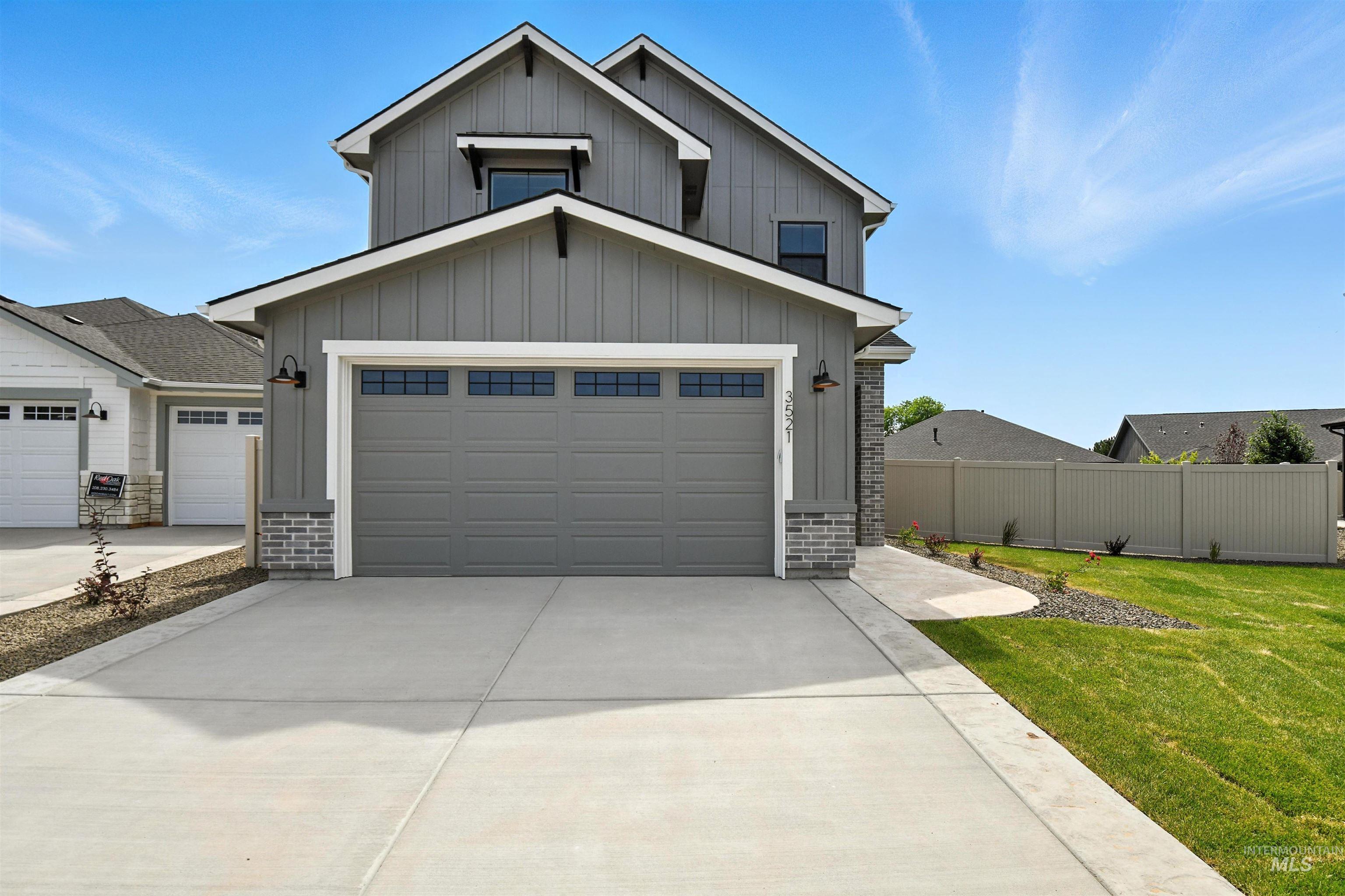 View of front of property with board and batten siding and concrete driveway