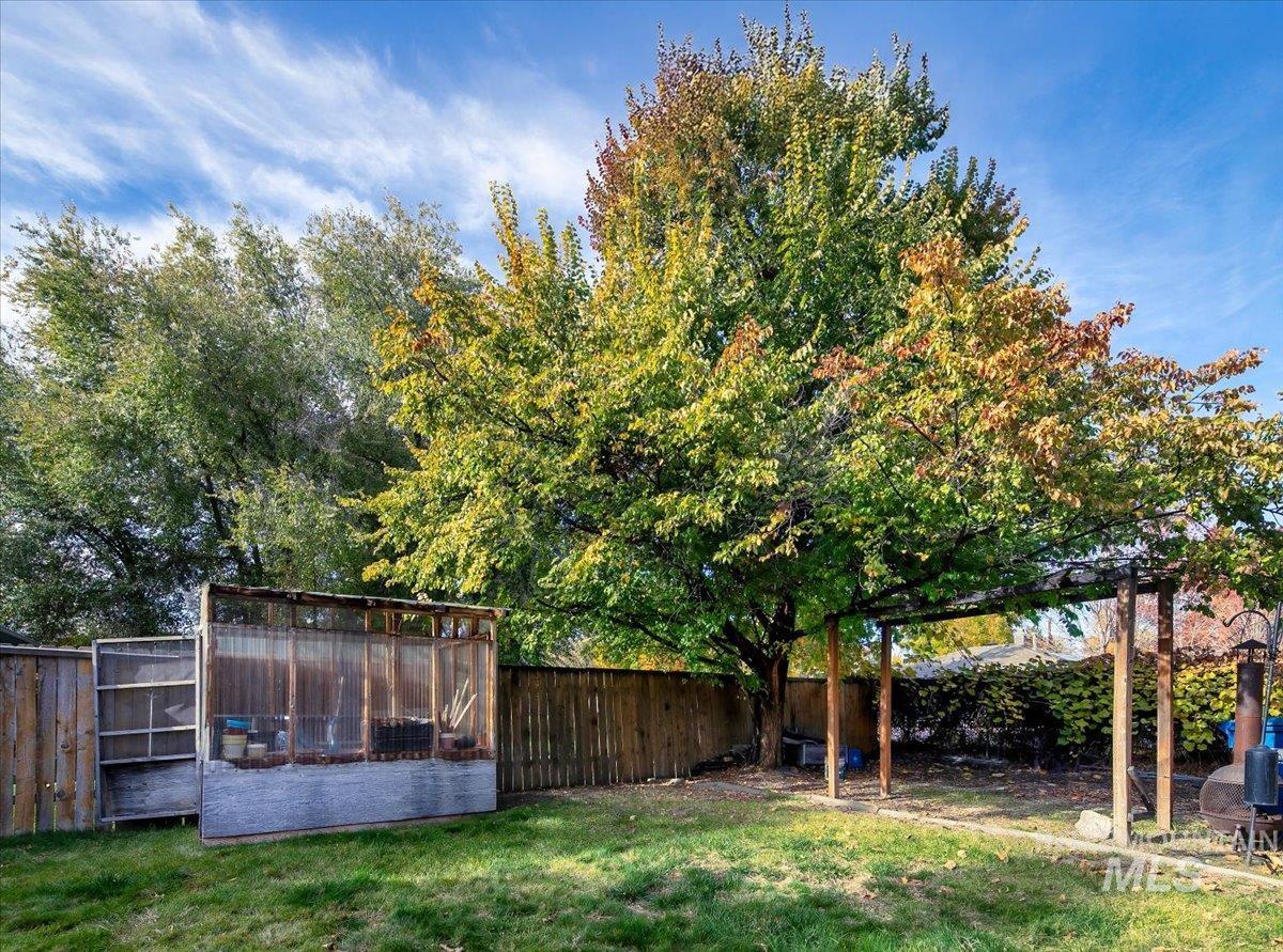 Fenced backyard featuring exterior structure and an outbuilding