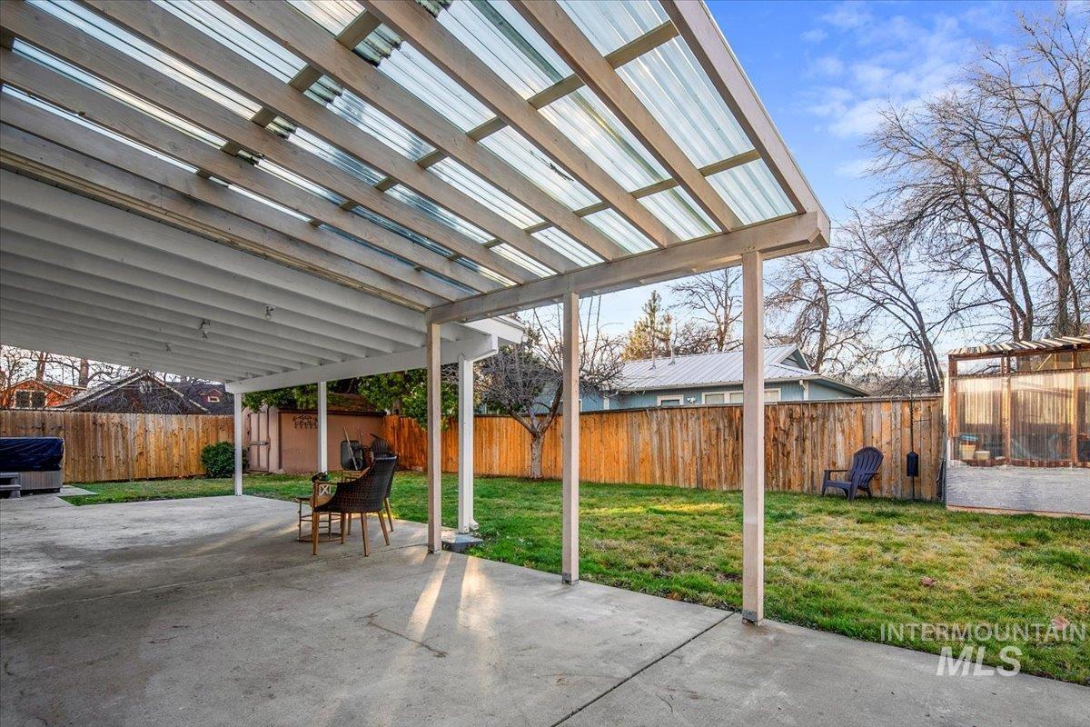 Fenced backyard featuring a storage shed and a patio area