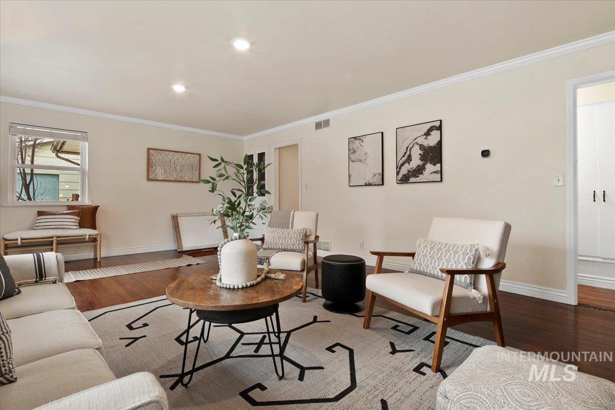 Living room with crown molding and wood finished floors