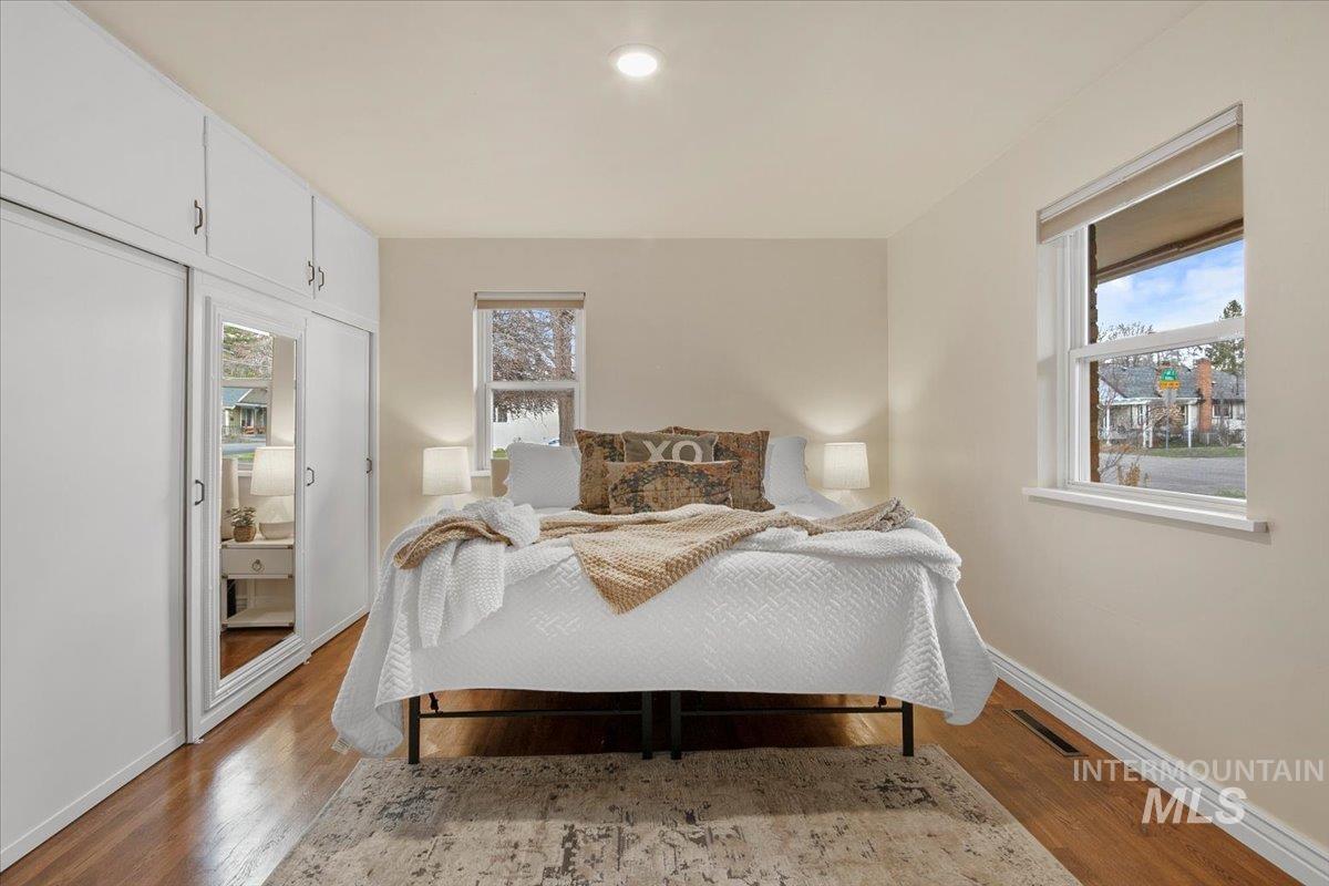 Bedroom featuring multiple windows and light wood-type flooring