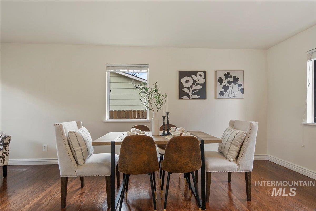 Dining space featuring baseboards and dark wood-style flooring