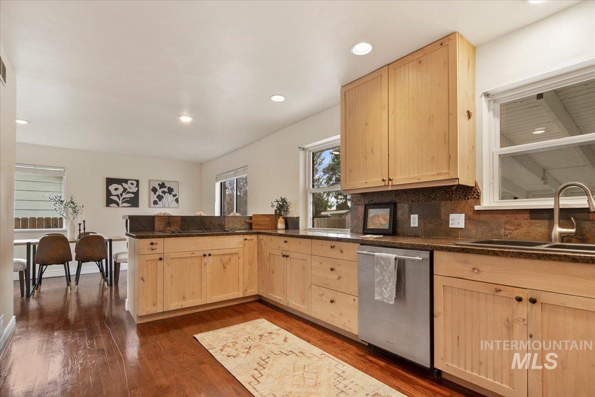 Kitchen with light brown cabinetry, recessed lighting, dishwasher, tasteful backsplash, and dark wood-type flooring