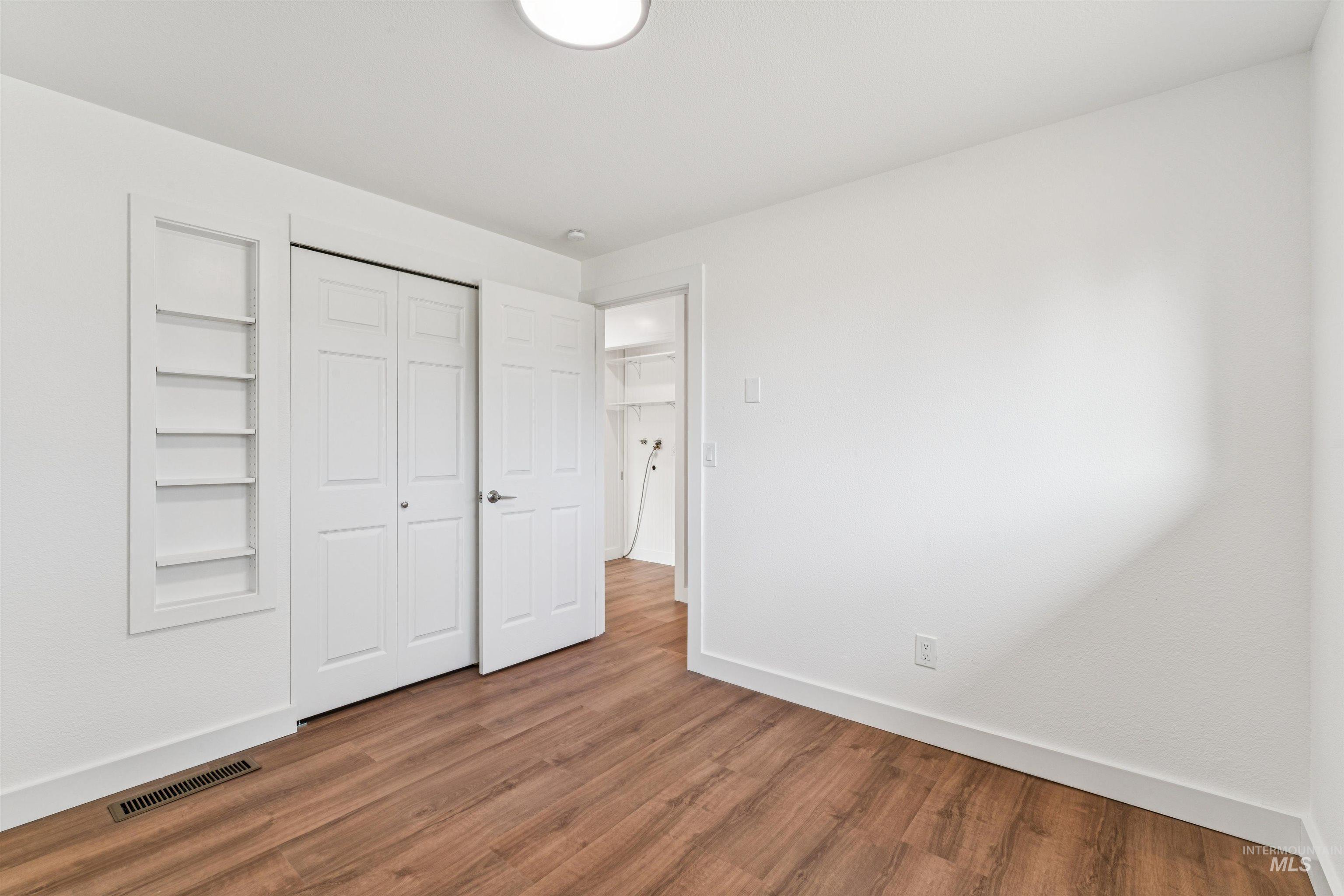 Unfurnished bedroom featuring wood finished floors and a closet