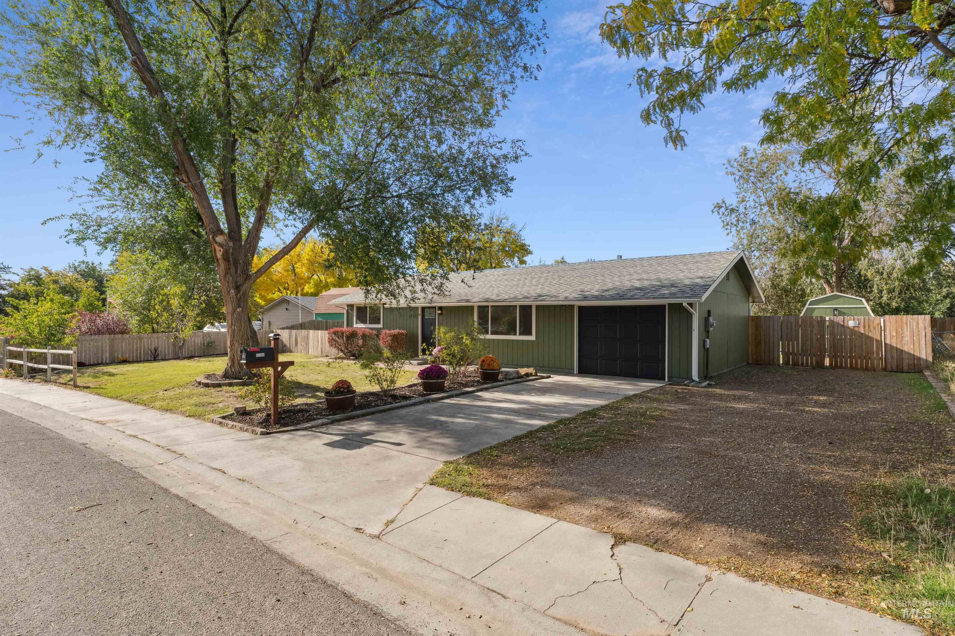 Ranch-style house featuring an attached garage, concrete driveway, and a shingled roof