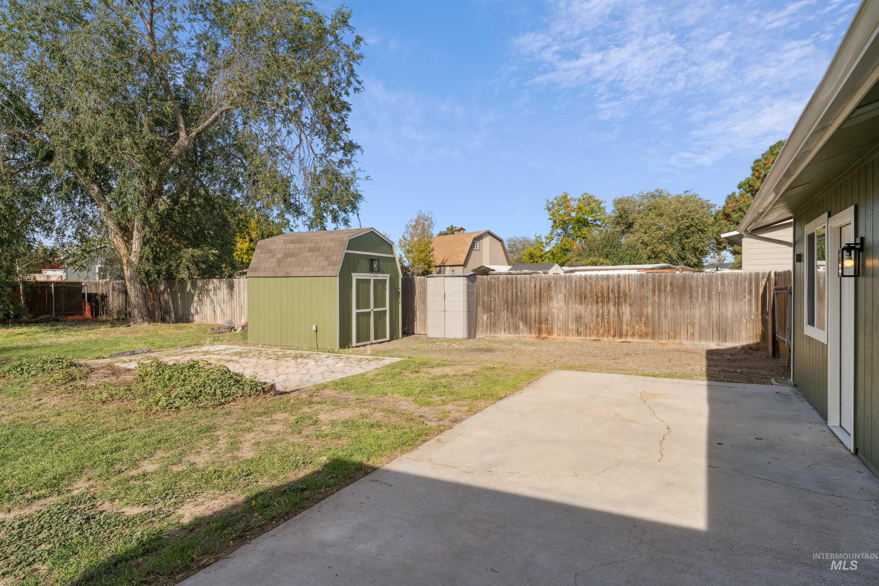 Fenced backyard with a storage shed and a patio