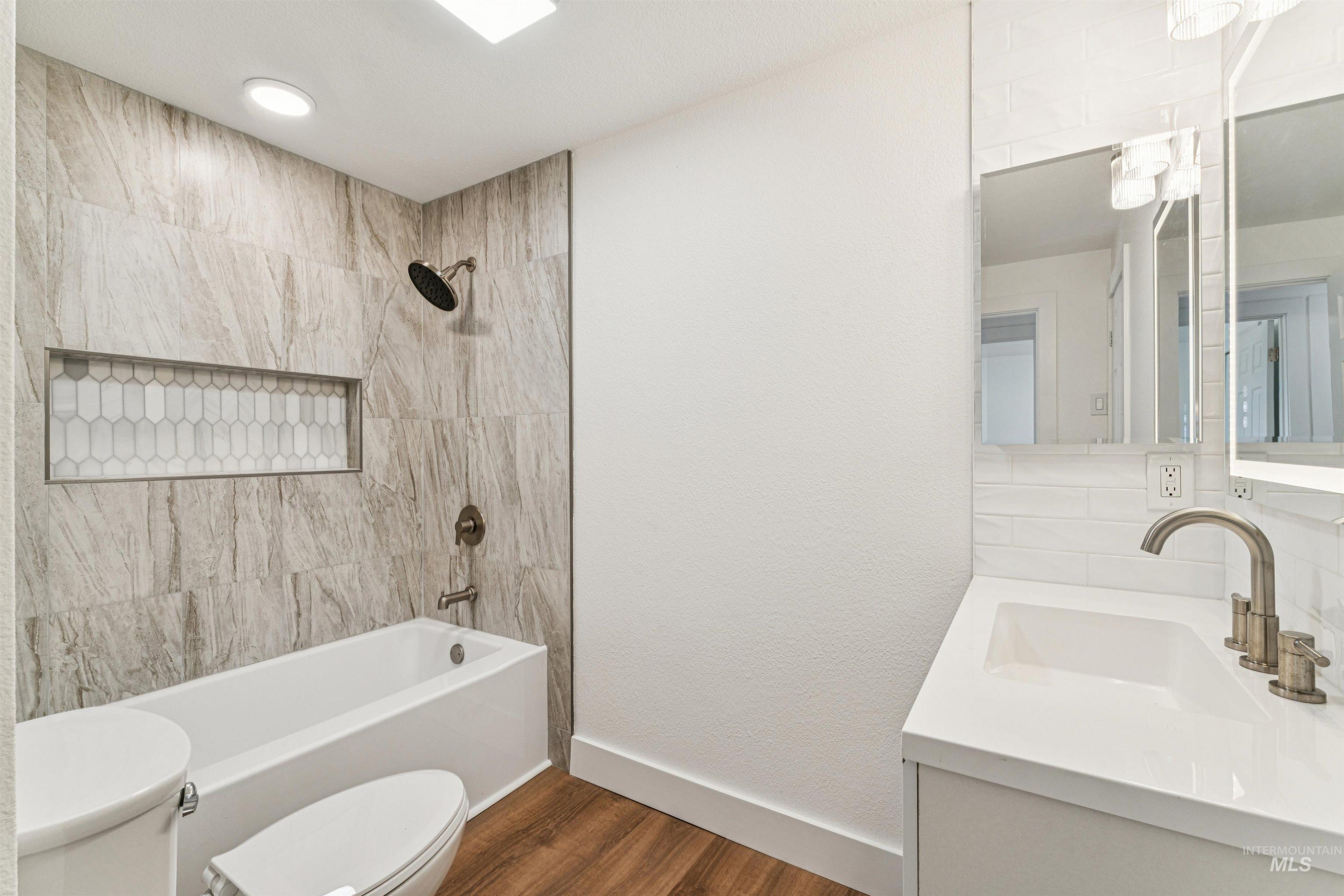 Full bathroom featuring vanity, bathtub / shower combination, and dark wood-style floors