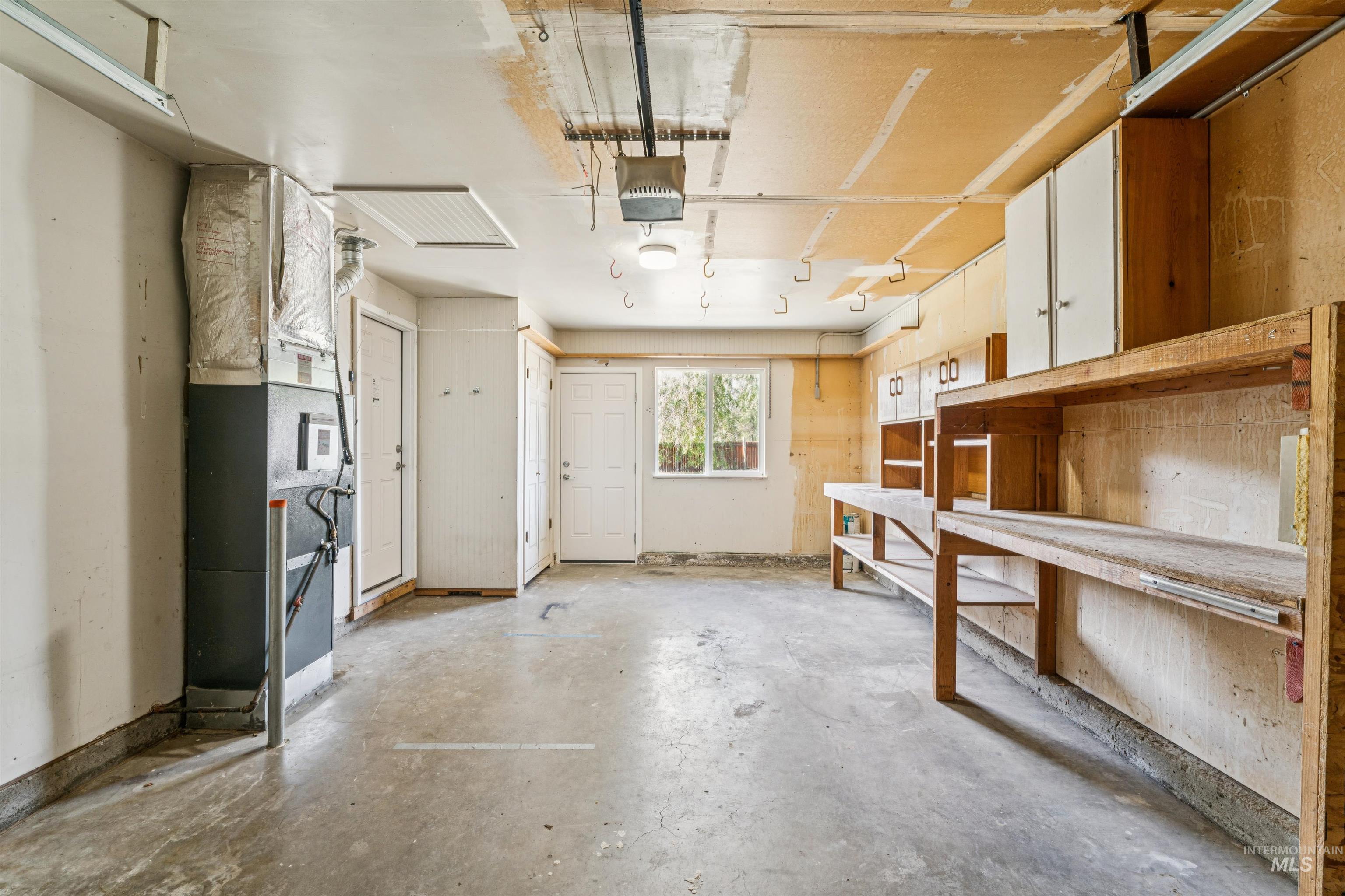 Garage featuring heating unit and a garage door opener