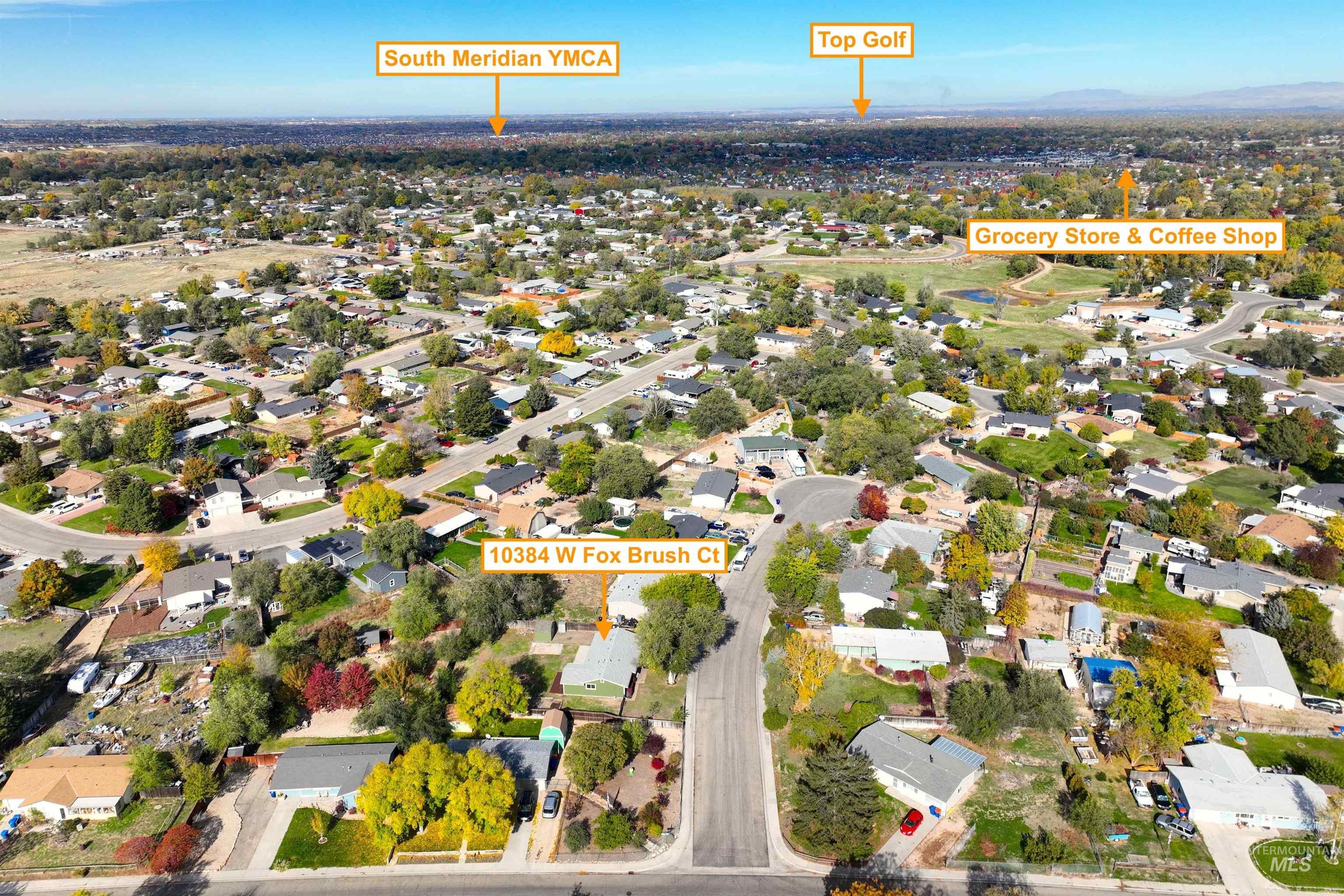 Aerial view of property and surrounding area featuring nearby suburban area