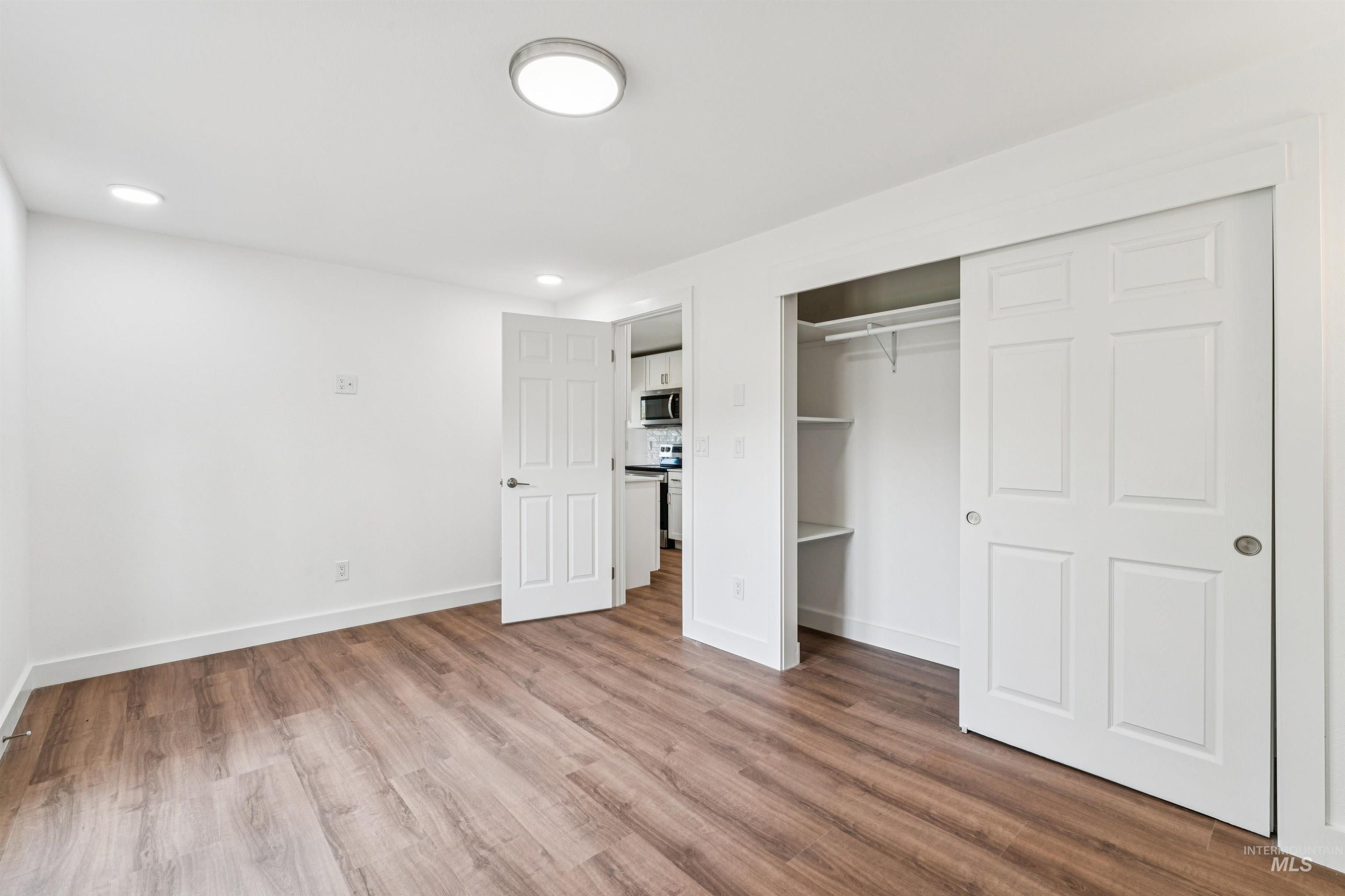 Unfurnished bedroom featuring wood finished floors, recessed lighting, and a closet