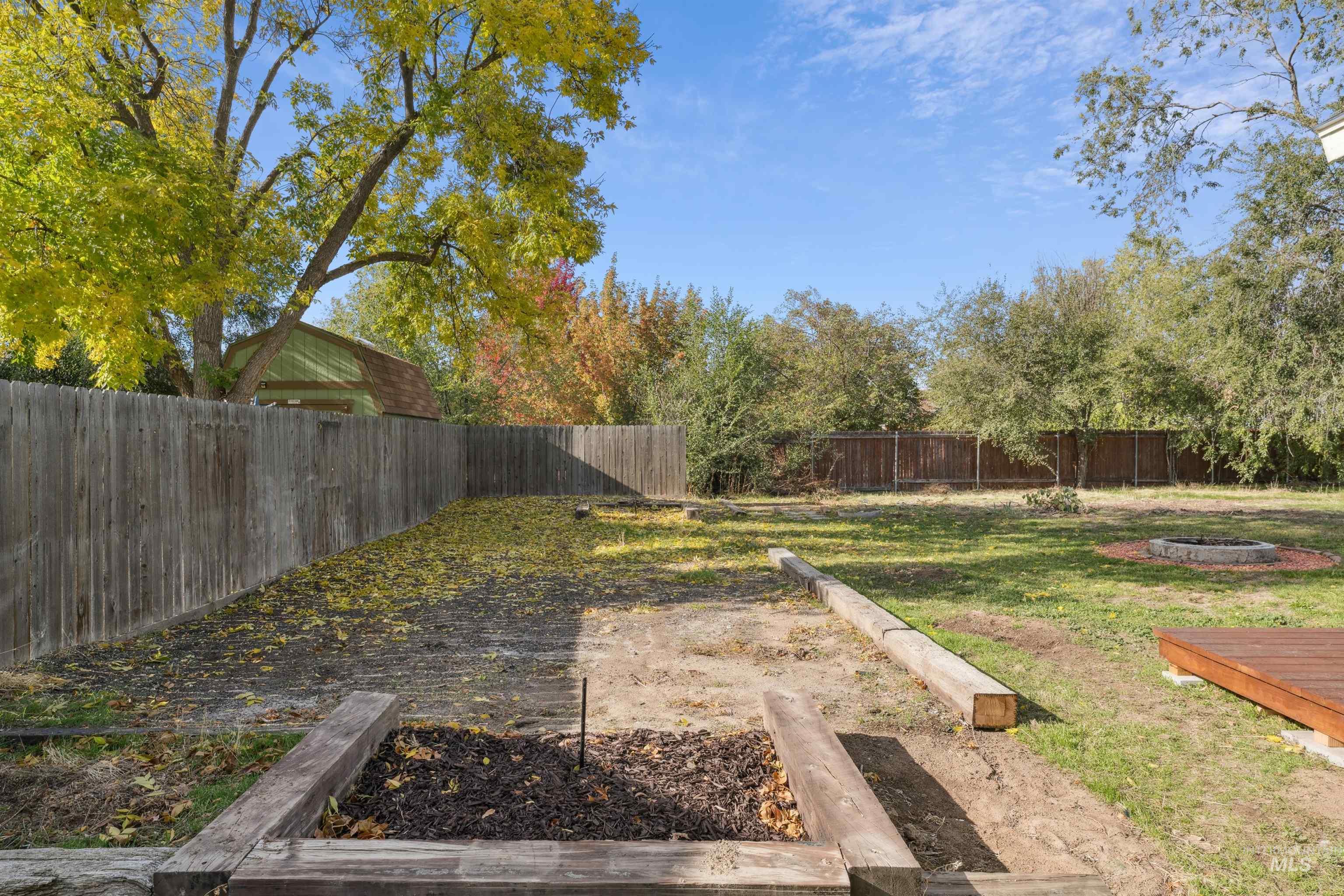Fenced backyard with a fire pit