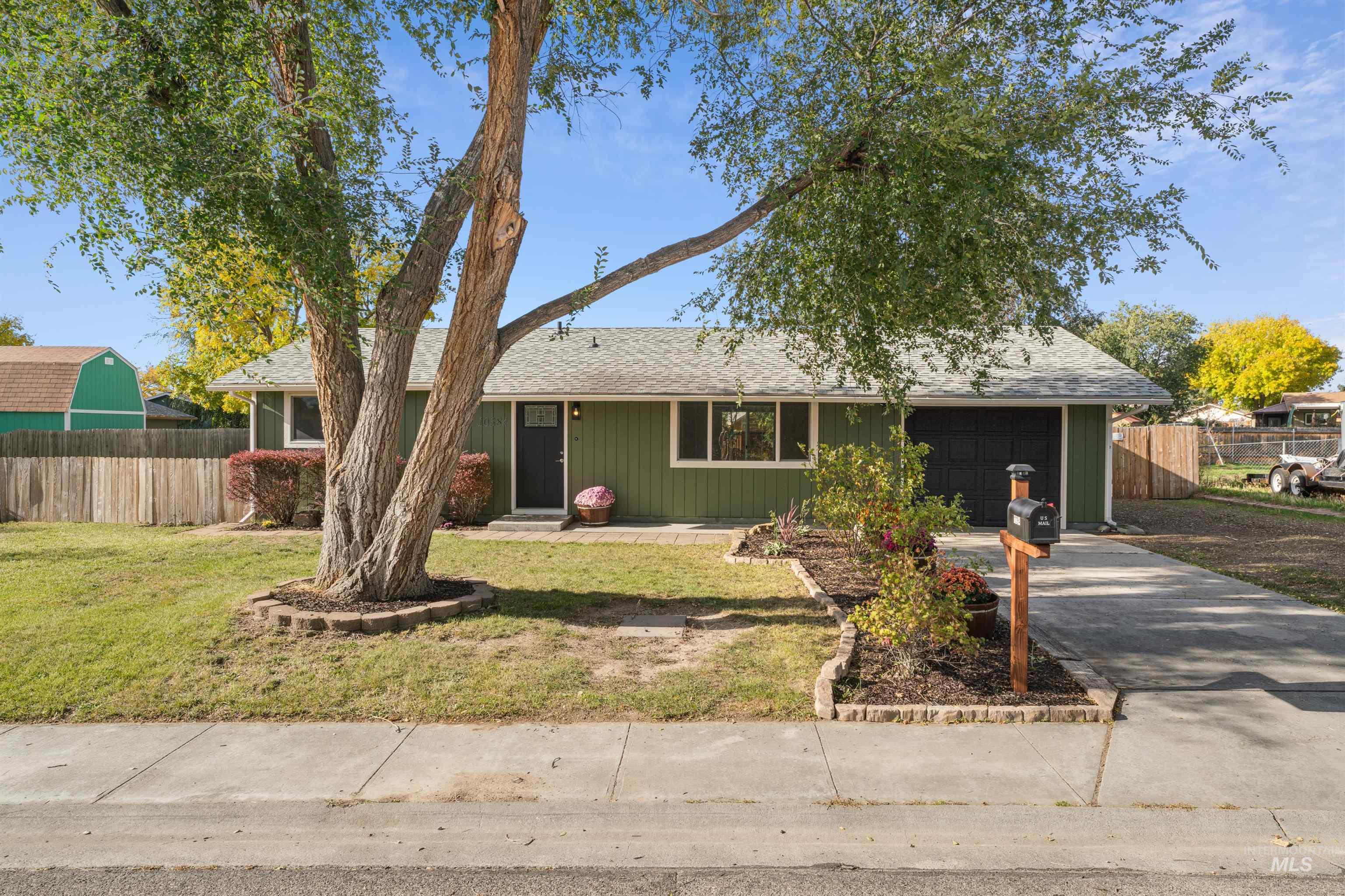 Ranch-style house featuring a shingled roof, driveway, and a garage
