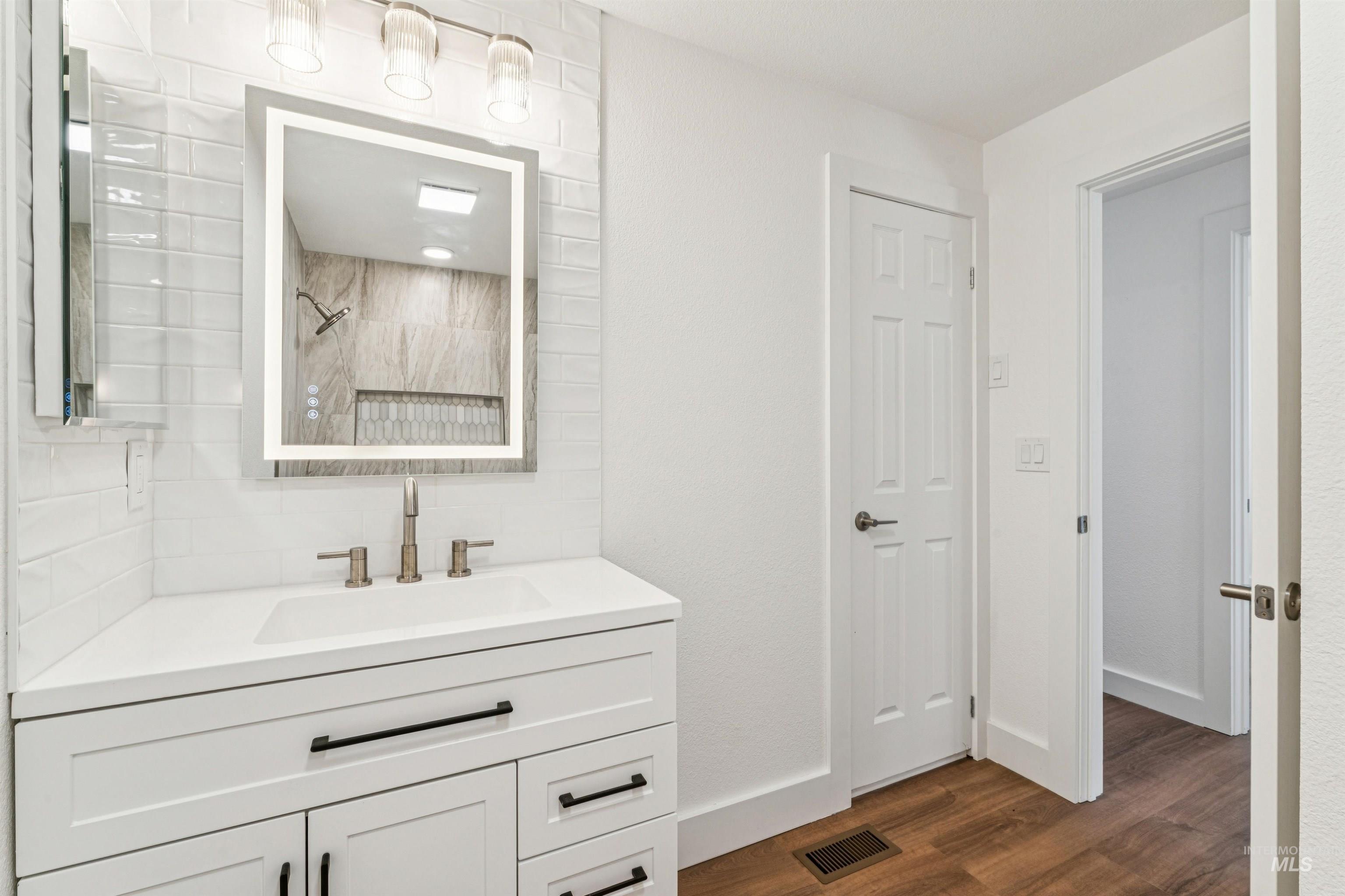 Bathroom featuring vanity, dark wood finished floors, and a shower