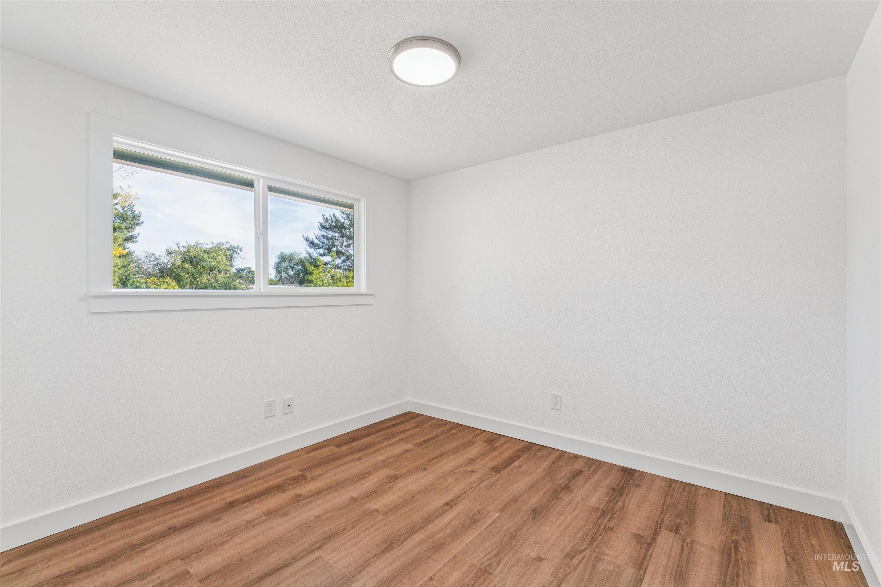 Spare room with wood finished floors and baseboards