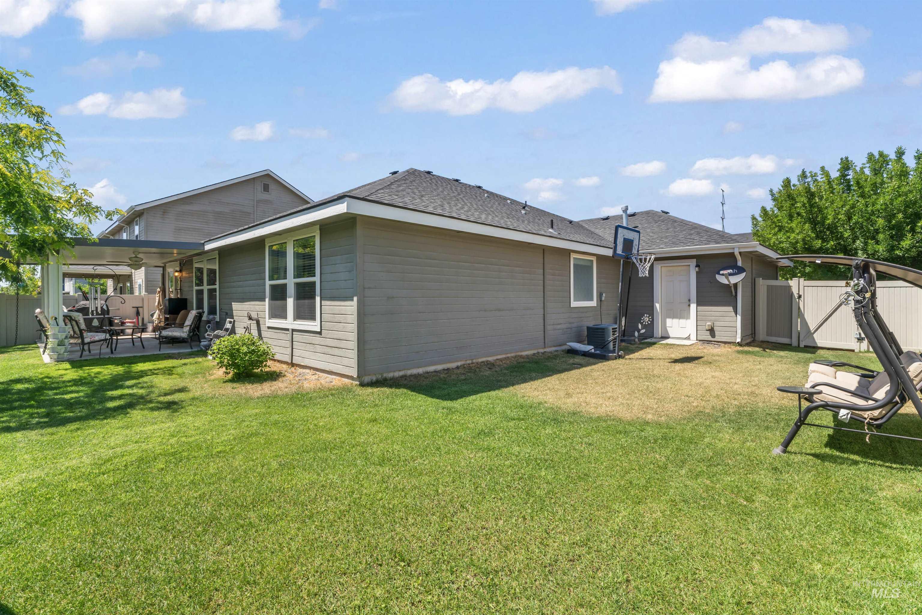 Rear view of house featuring a fenced backyard, a patio area, a gate, ceiling fan, and a shingled roof