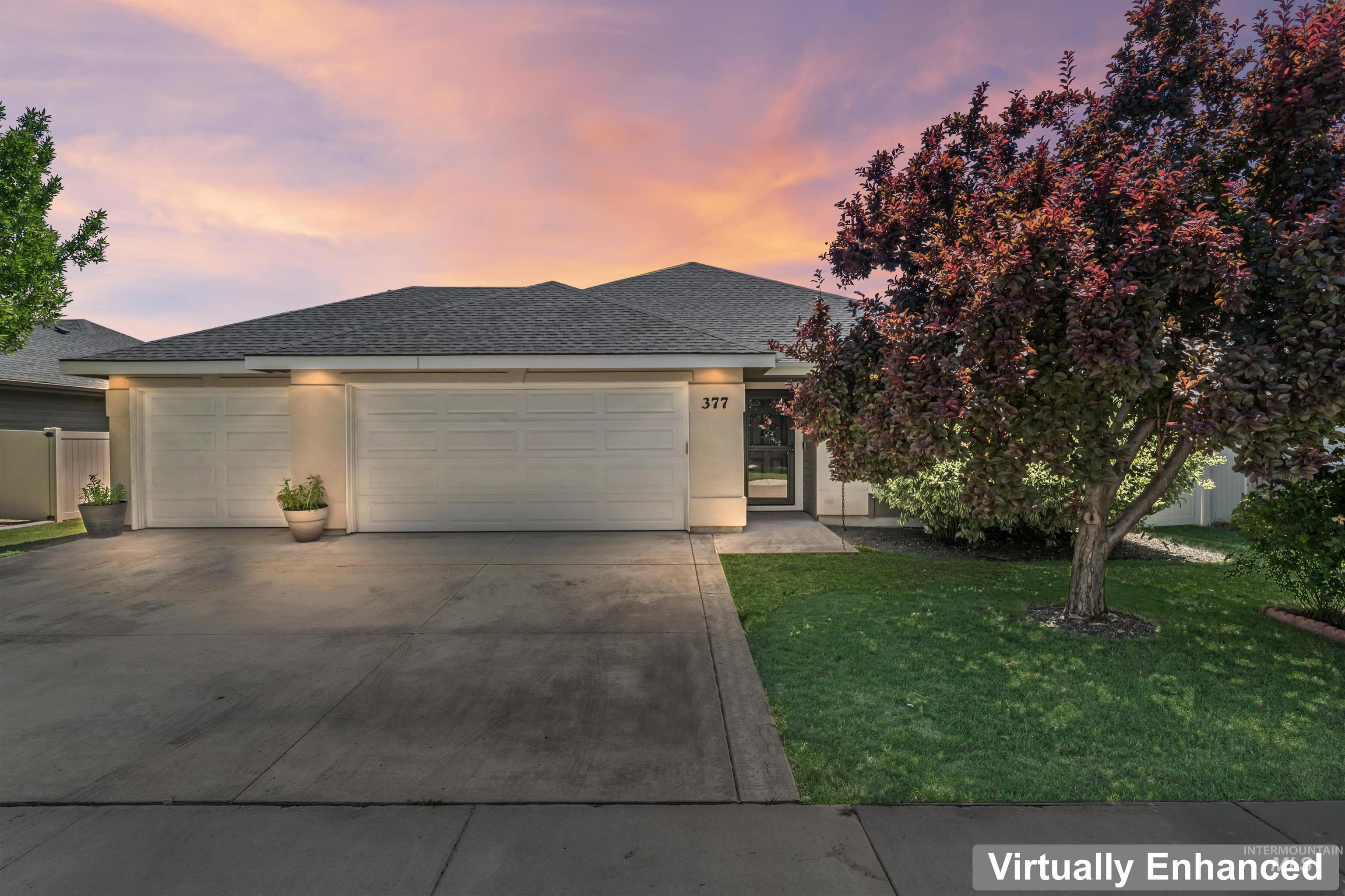 View of front facade with an attached garage, concrete driveway, a shingled roof, and stucco siding