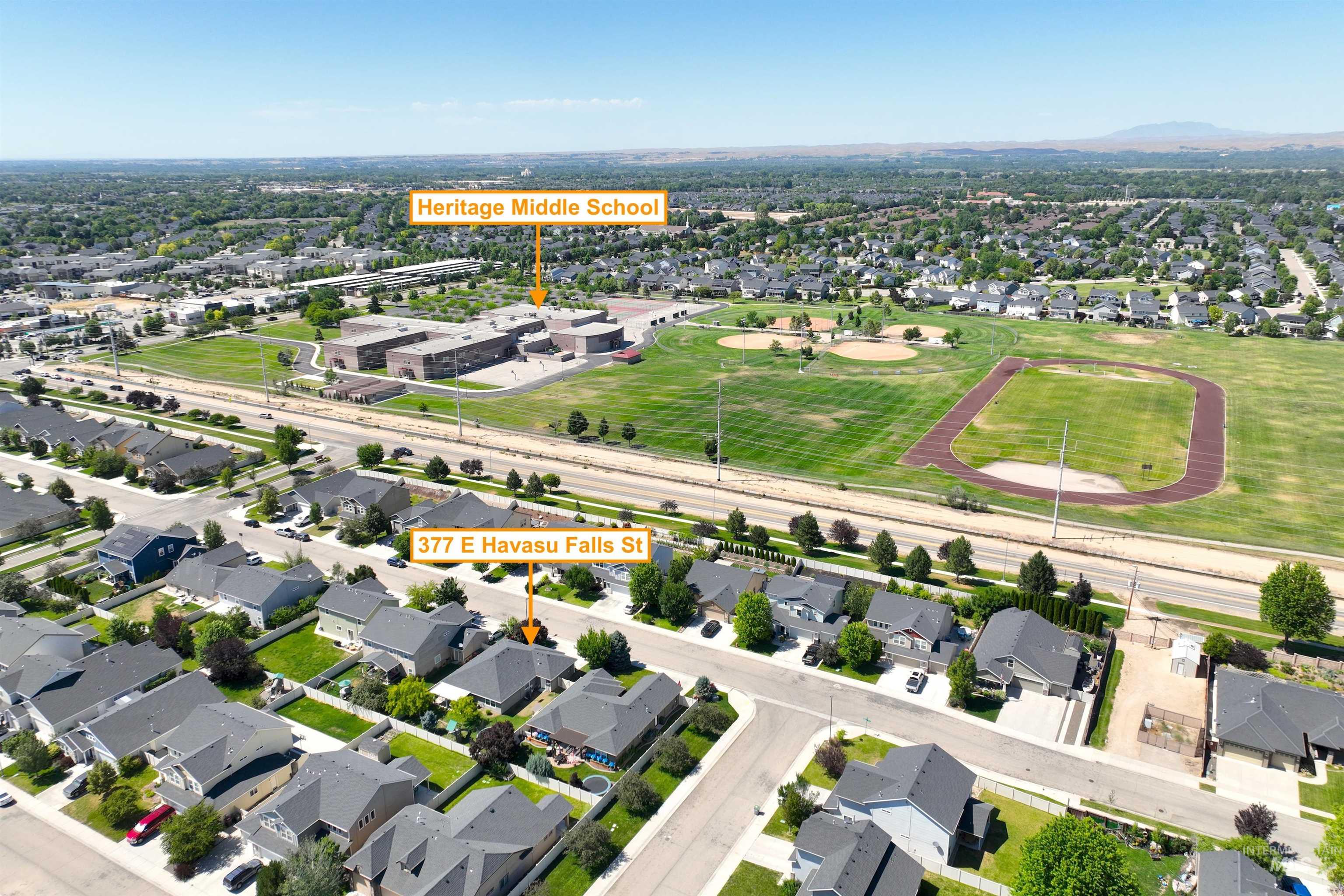 Aerial view of property and surrounding area with nearby suburban area