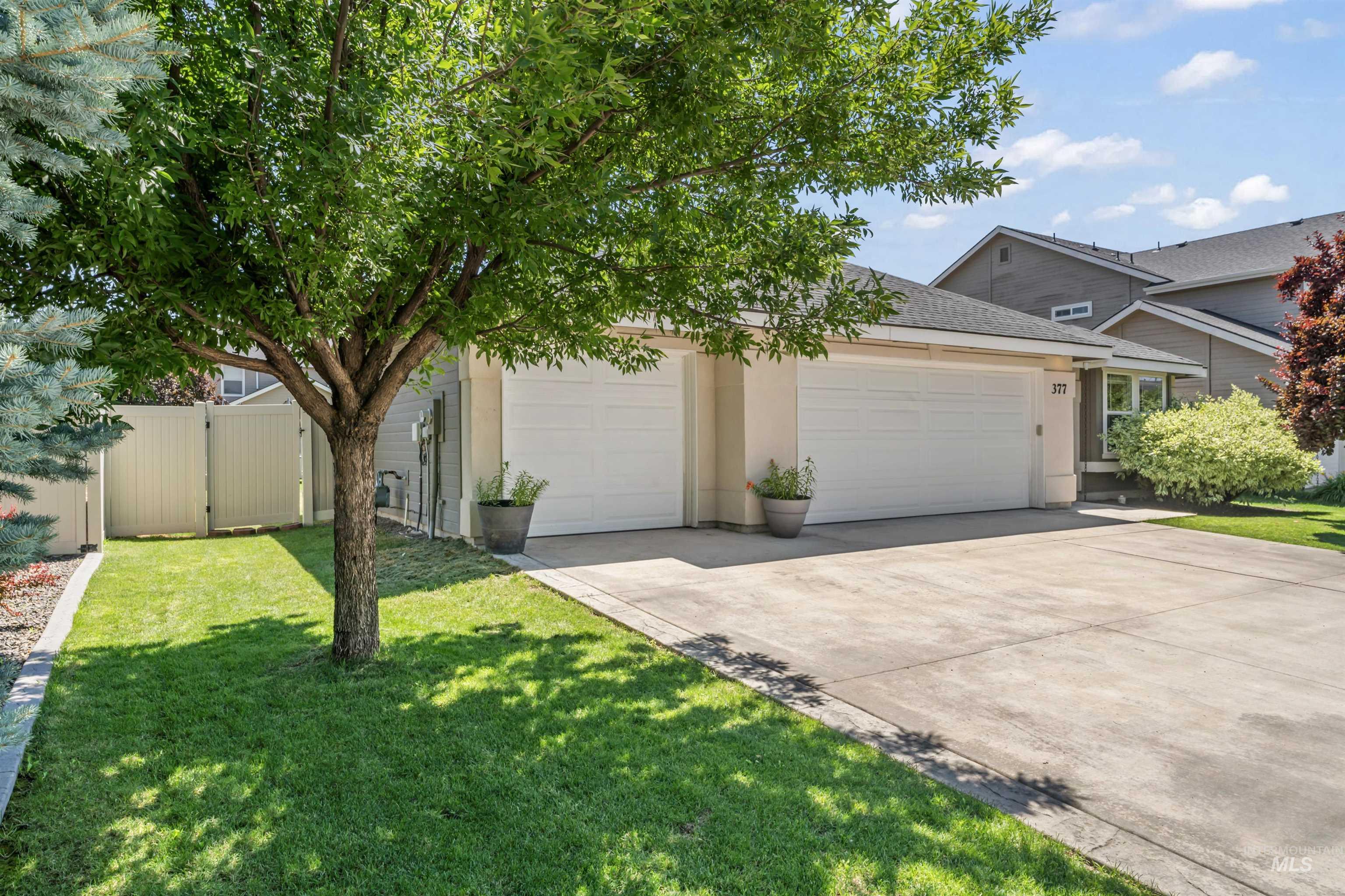 View of front facade with a garage, concrete driveway, stucco siding, and roof with shingles