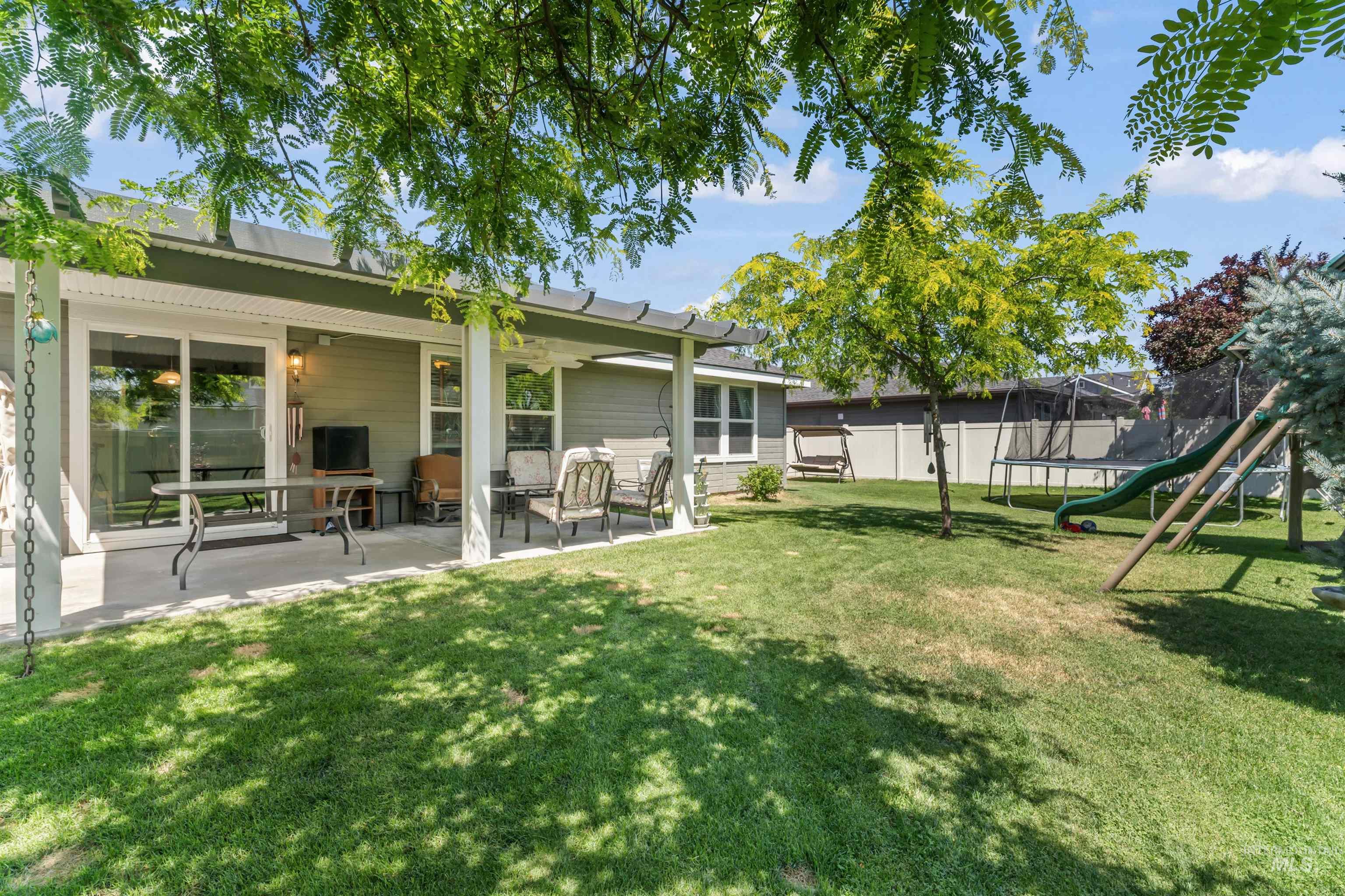 View of yard featuring a trampoline, a patio, and a playground