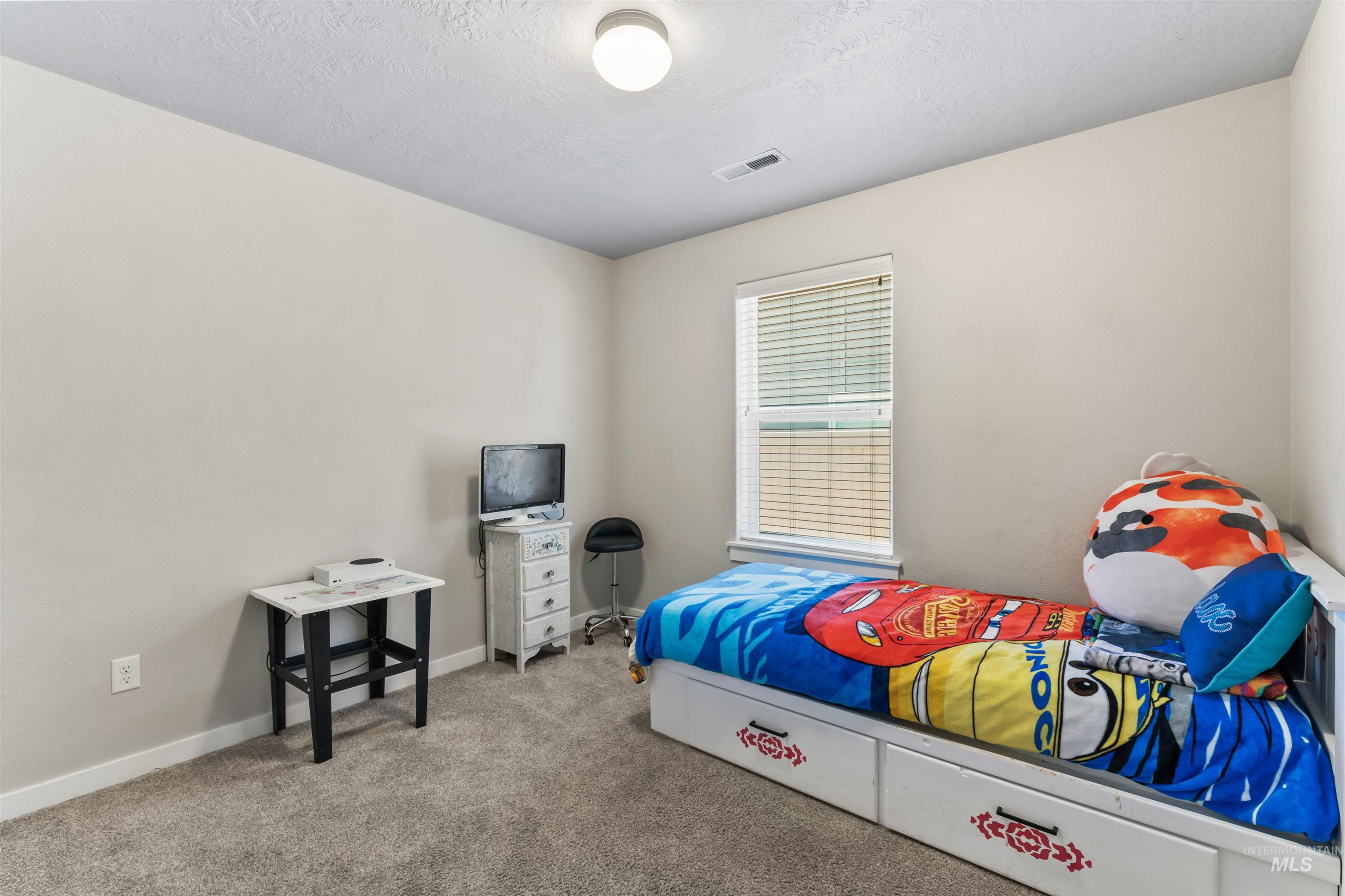 Bedroom featuring carpet flooring and a textured ceiling