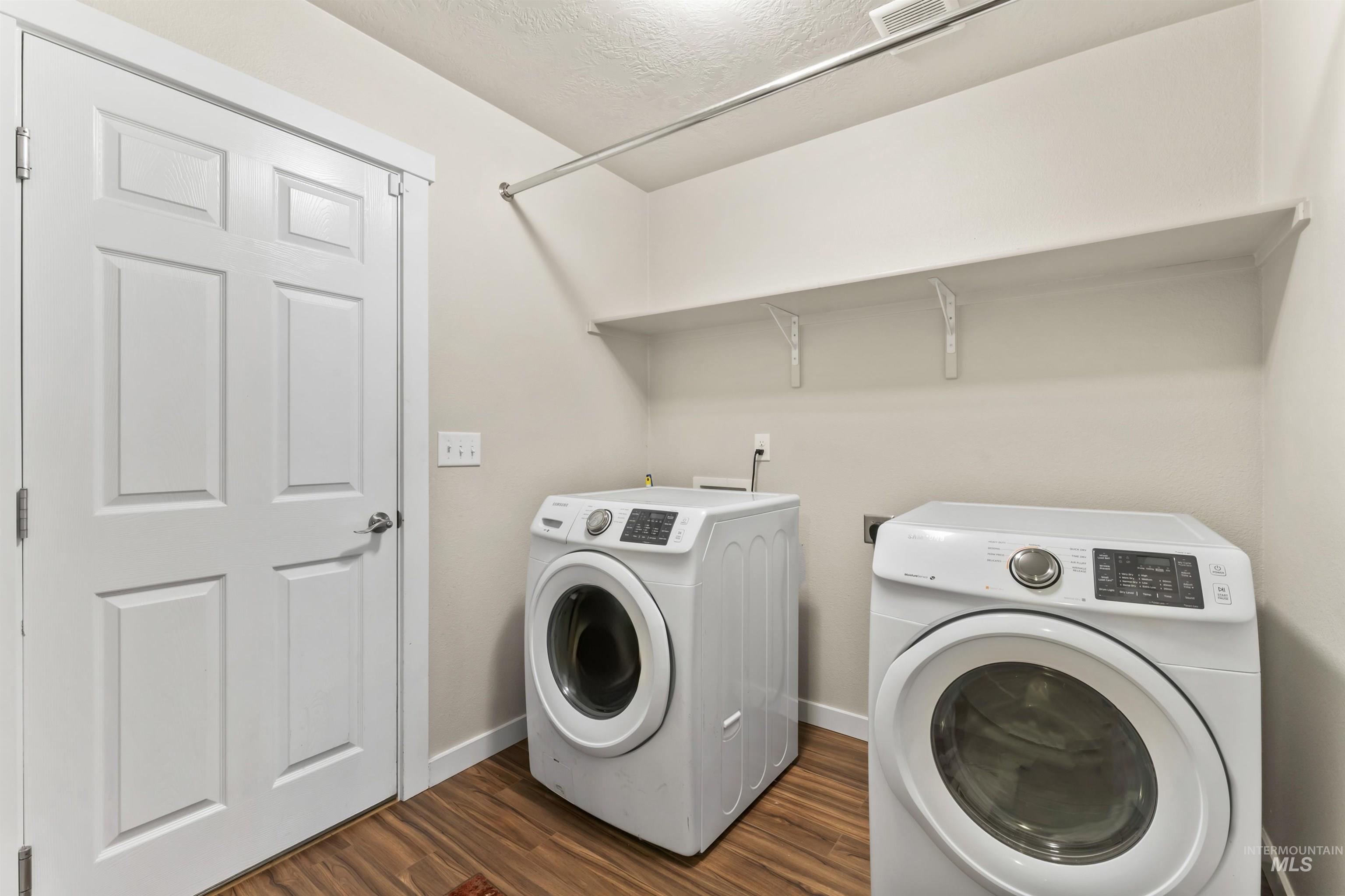 Laundry room featuring separate washer and dryer and dark wood-type flooring