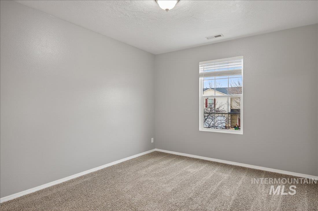 Spare room with a textured ceiling and carpet flooring
