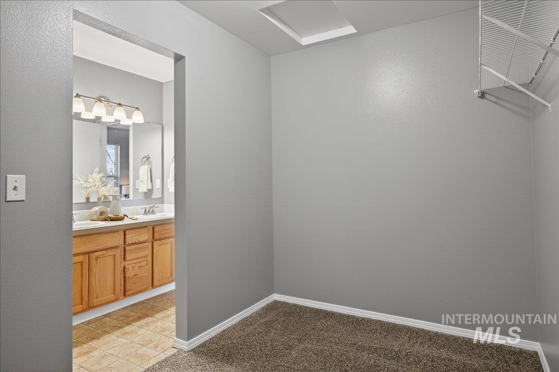 Bathroom with double vanity and light carpet