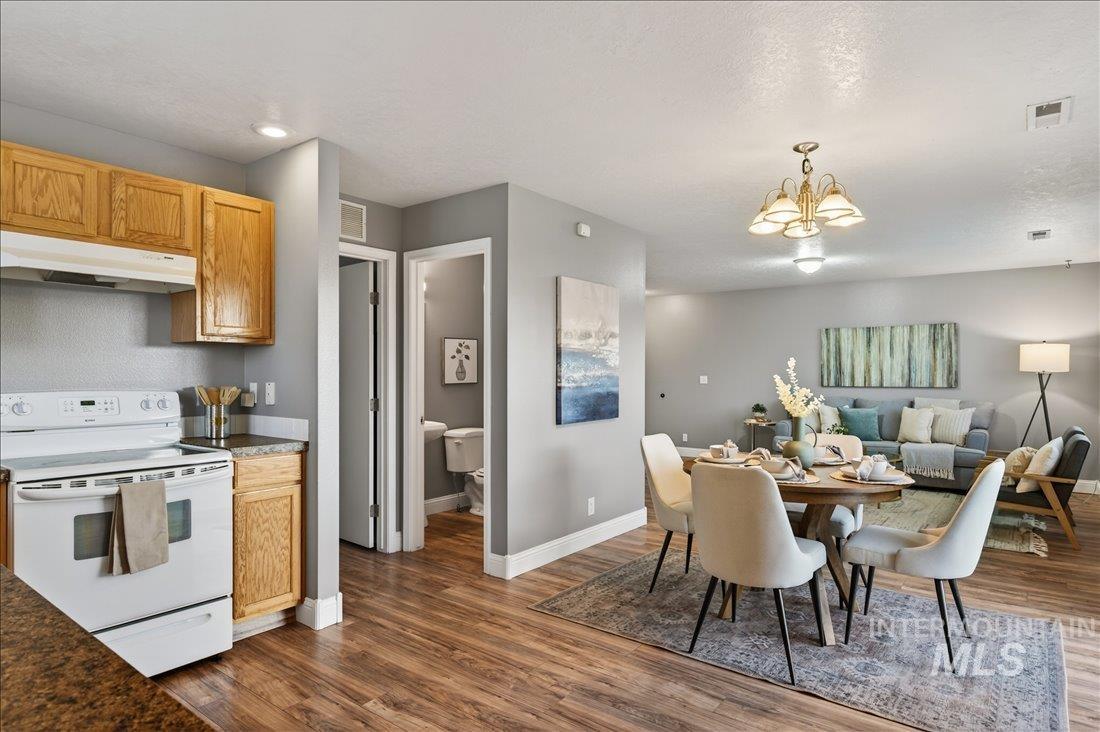 Dining space featuring dark wood-style floors, a chandelier, and a textured ceiling