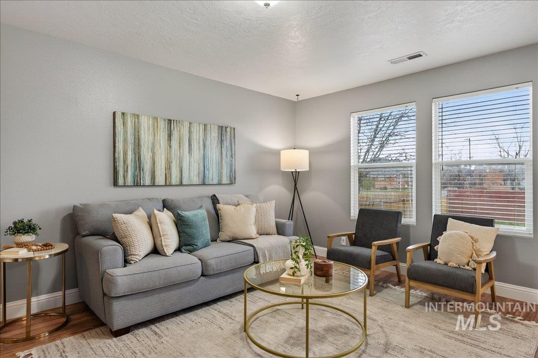 Living room with a textured ceiling and wood finished floors