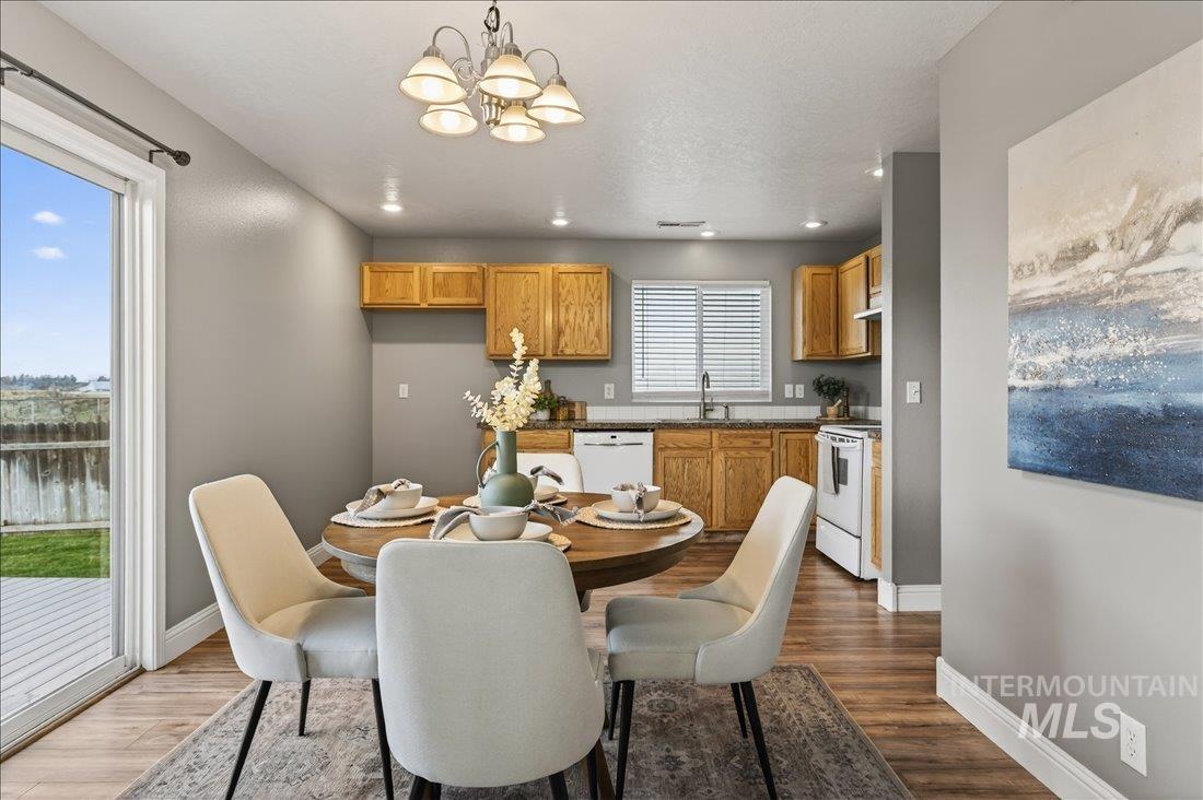 Dining room featuring a chandelier, dark wood-style floors, a water view, and recessed lighting