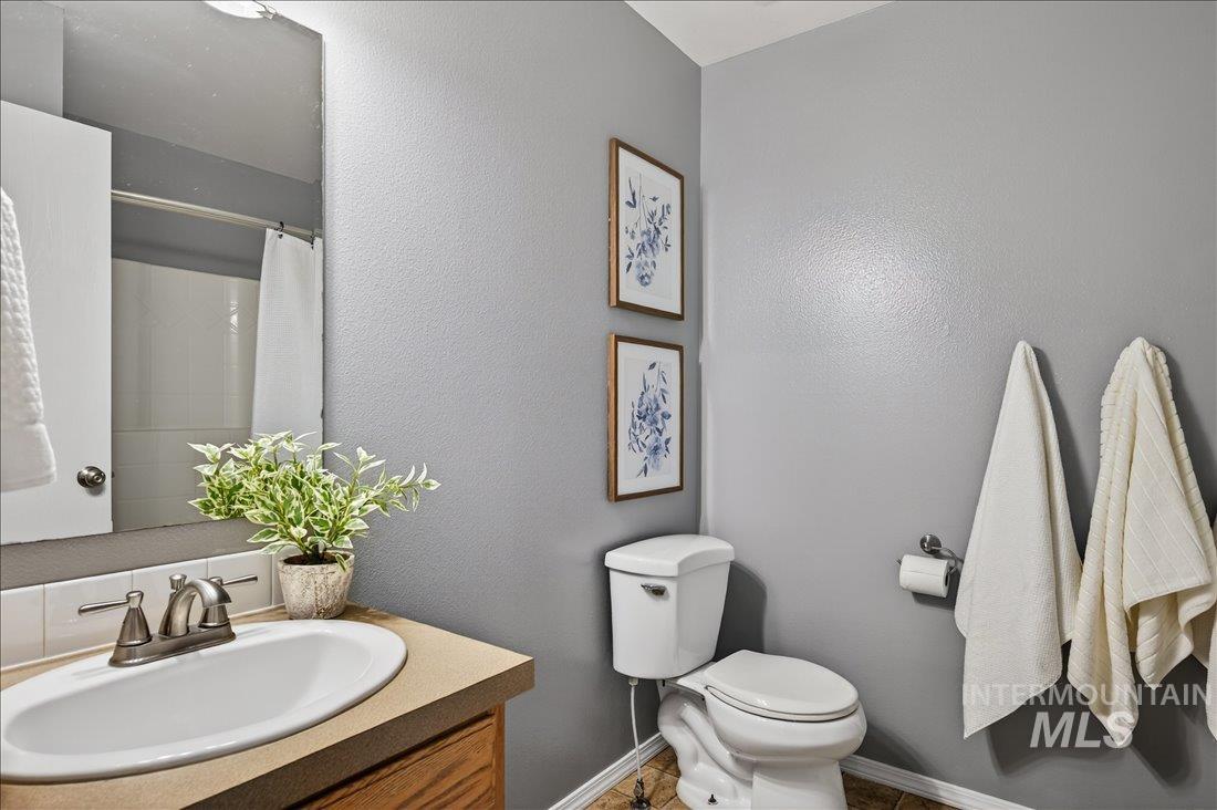 Bathroom with vanity, a shower with curtain, and a textured wall
